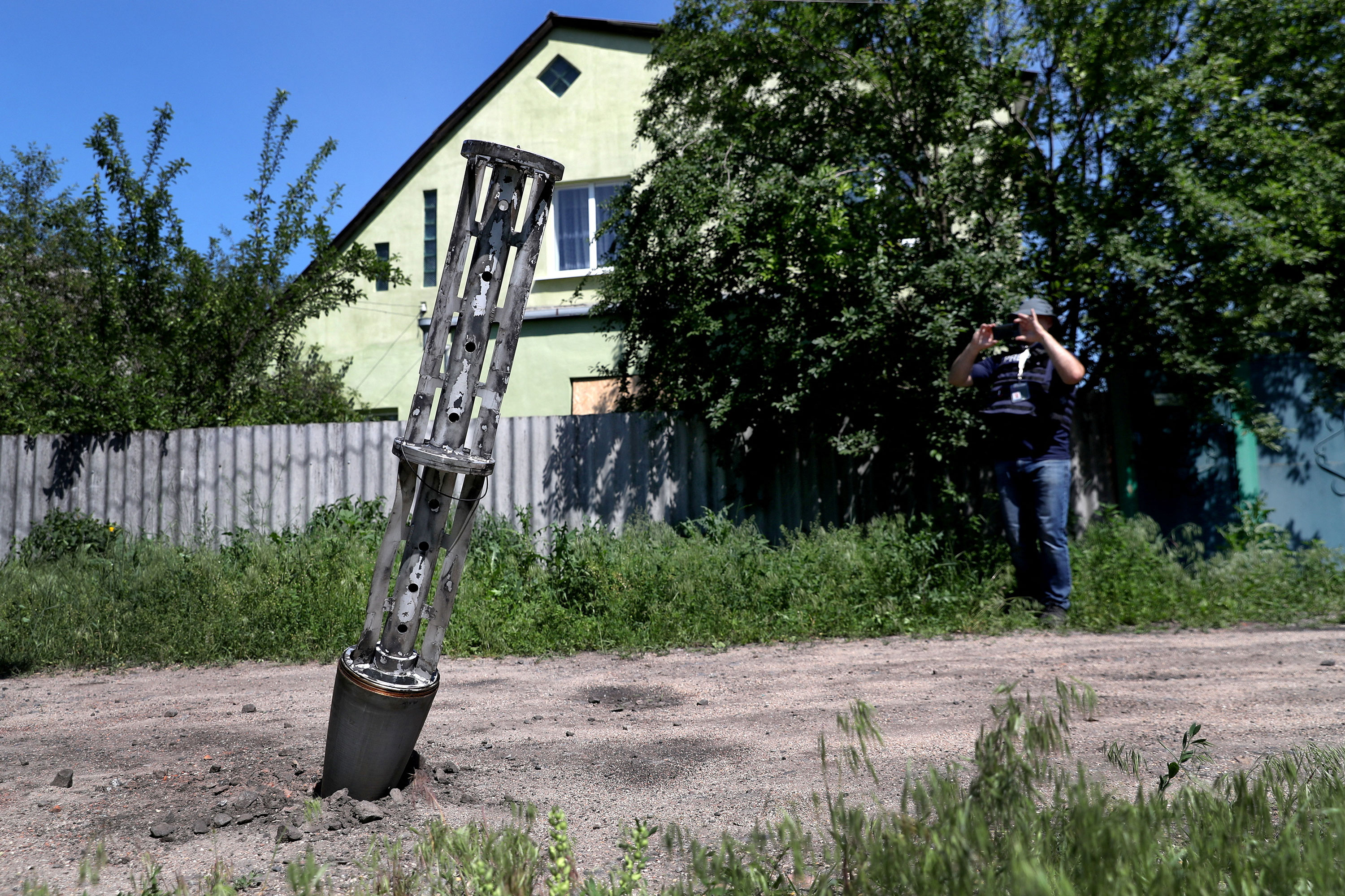 An emptied cluster munition container is seen stuck in the ground following a military strike on the outskirts of Kharkiv, Ukraine, on June 10, 2022.