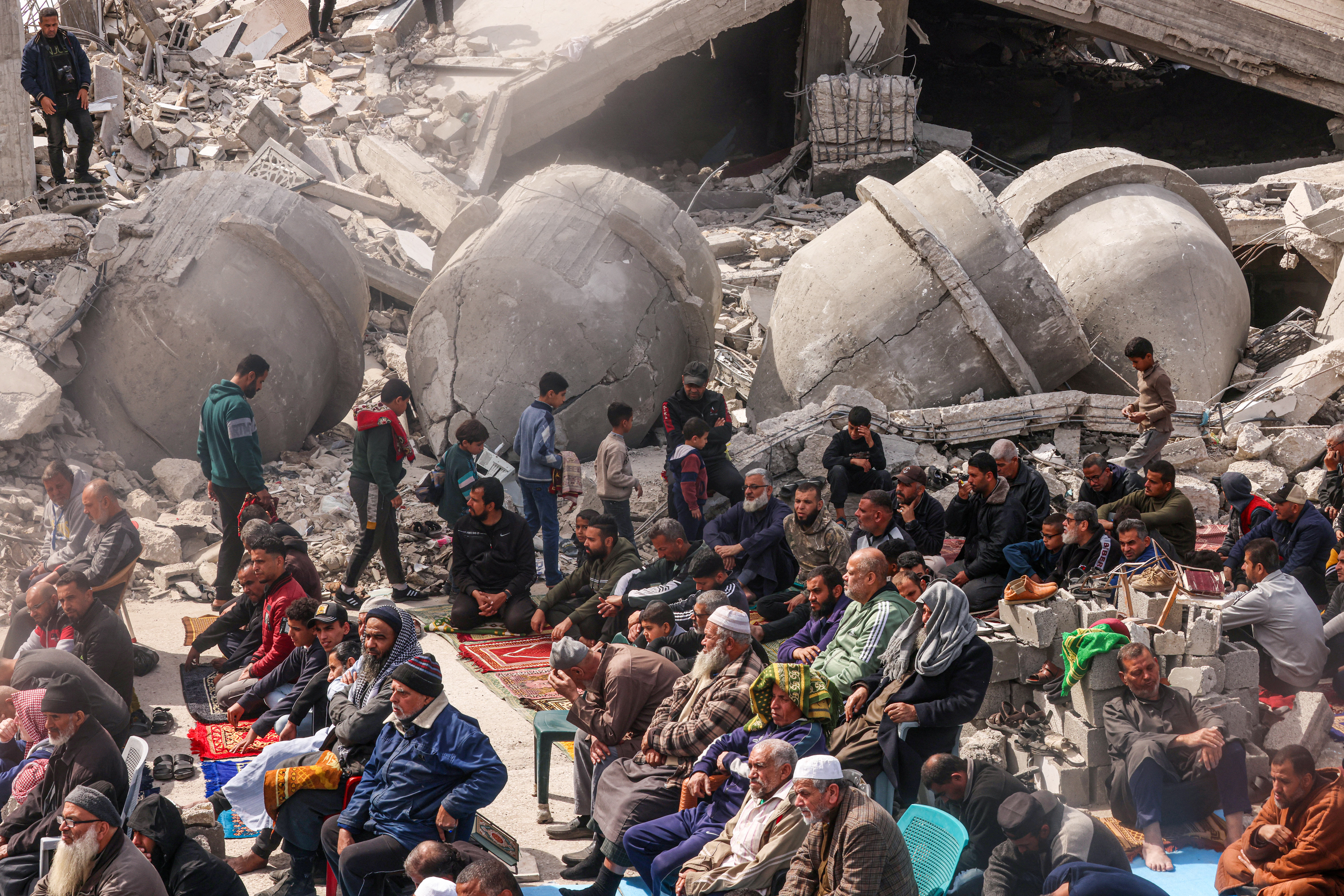 People attend the Friday noon prayers by the ruins of a mosque destroyed in Israeli strikes in Rafah, Gaza, on March 1.