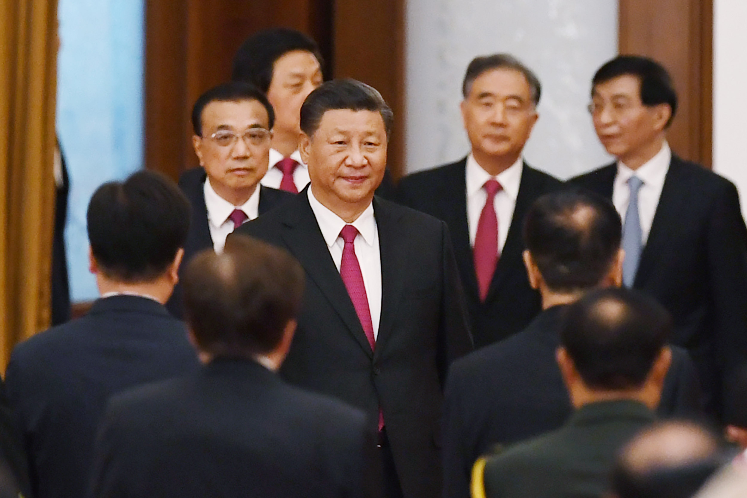 Chinese President Xi Jinping (C) arrives with Premier Li Keqiang (L) for a reception at the Great Hall of the People on the eve of China's National Day, on September 30. 