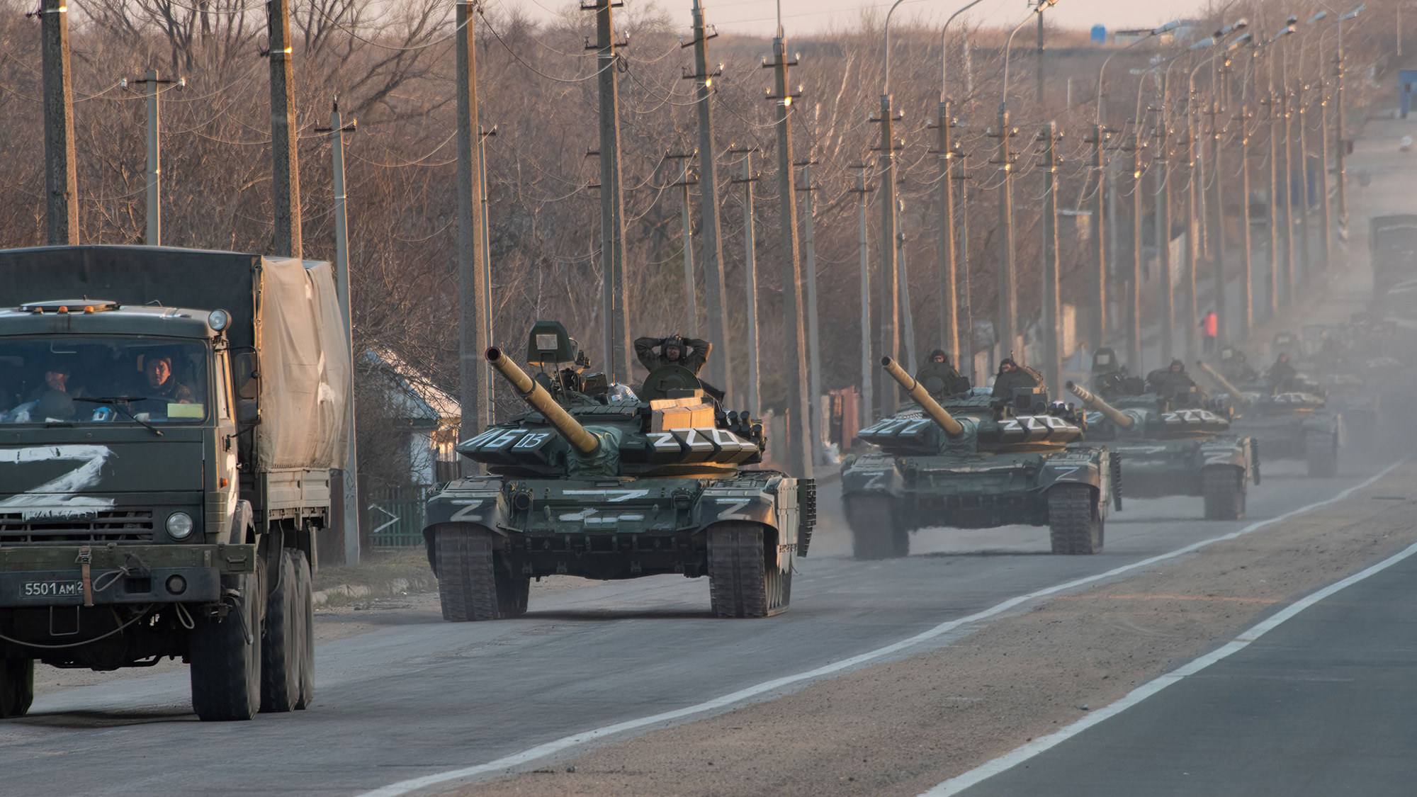 A column of tanks marked with the symbol Z extends into the distance as they advance north along the Mariupol-Donetsk highway on March 23. 