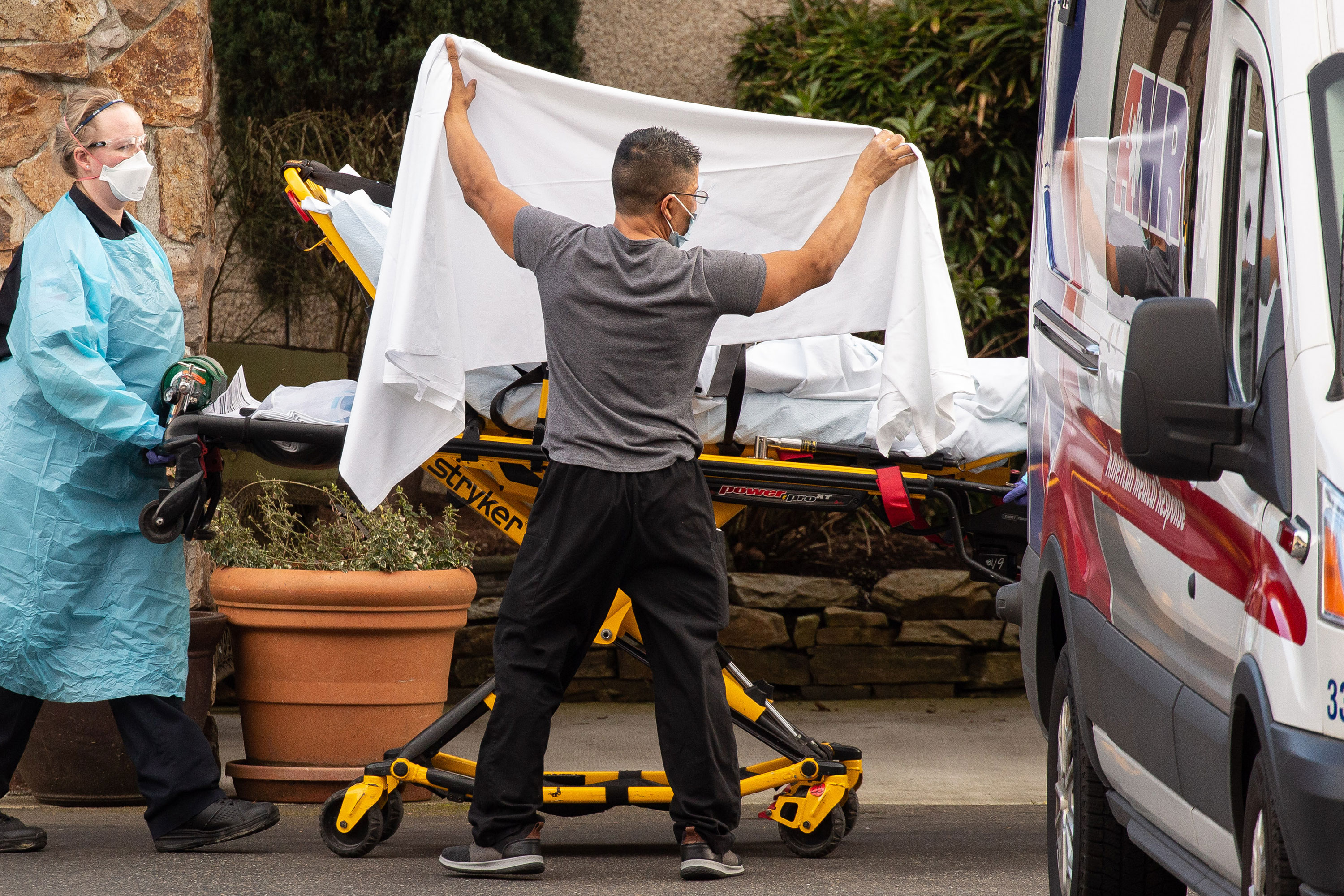 Healthcare workers transport a patient to an ambulance at Life Care Center of Kirkland on February 29, in Kirkland, Washington state. 