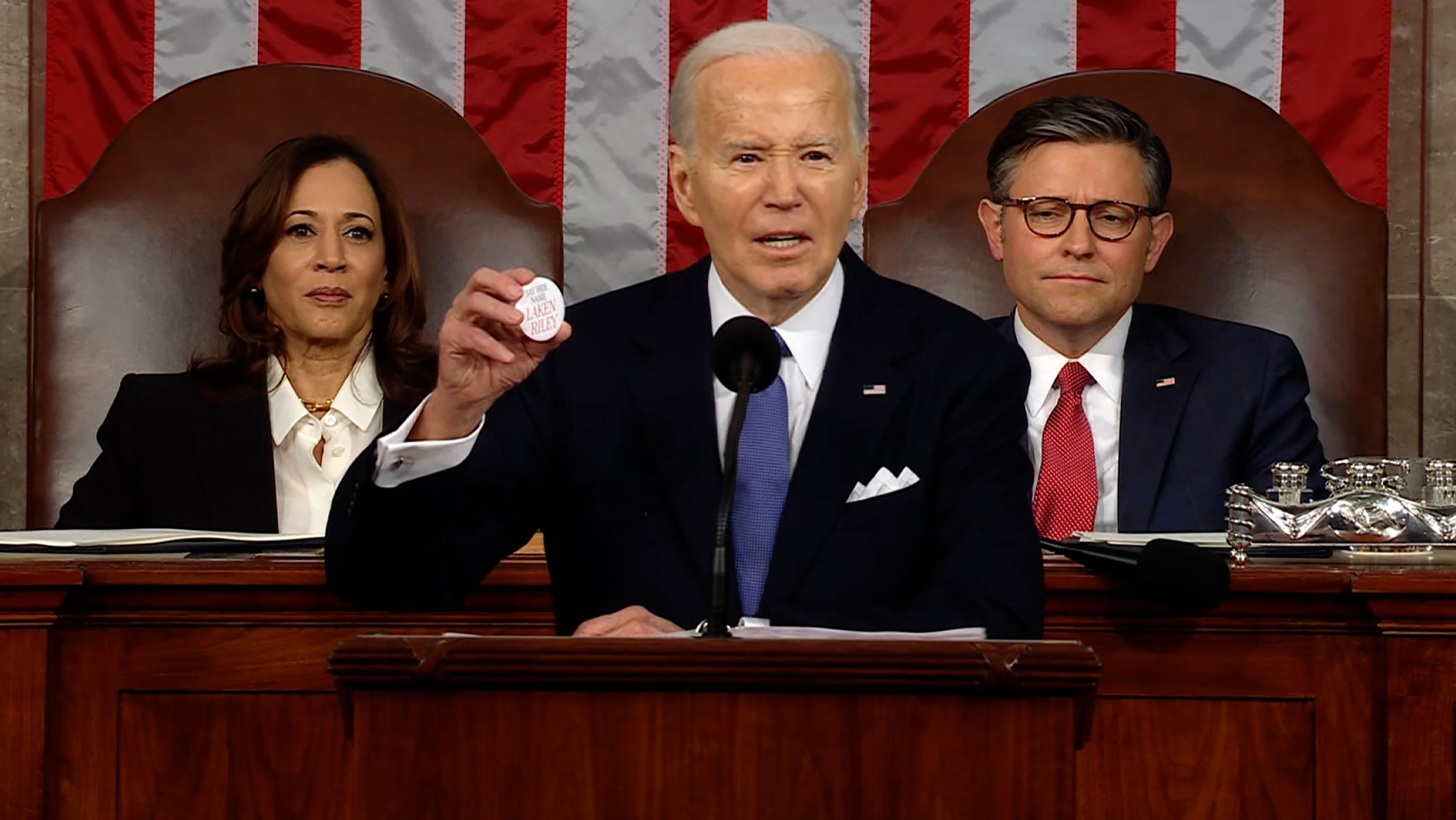 President Joe Biden holds up a button with Laken Riley's name during his State of the Union address. 