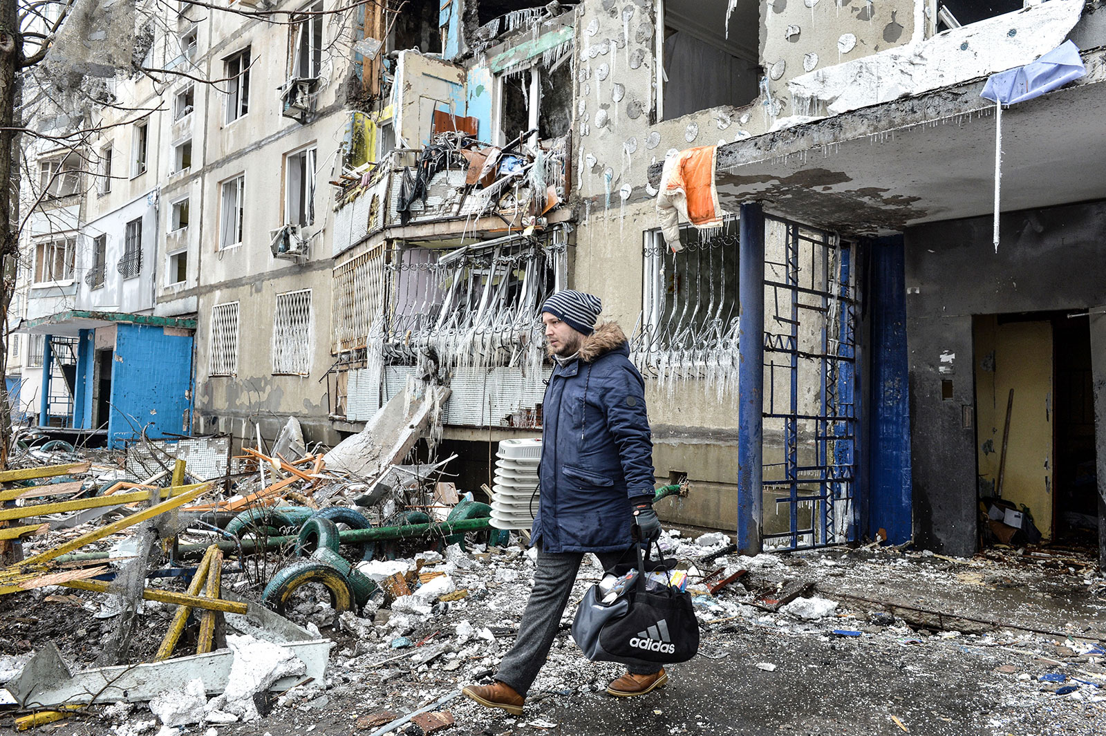 A man leaves an apartment building damaged after shelling the day before in Kharkiv on March 8. 