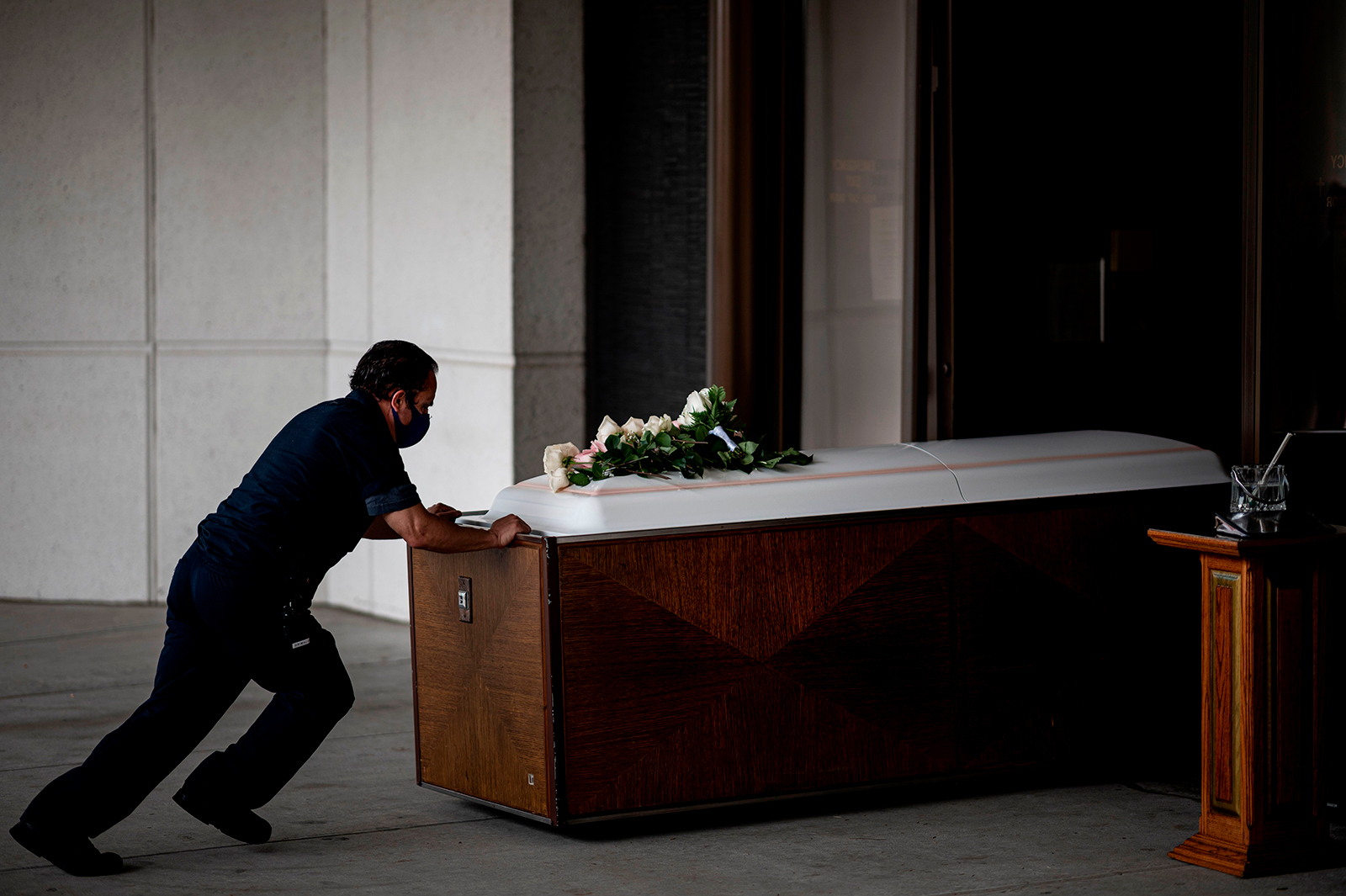 A funeral worker pushes the coffin of a Covid-19 victim at St. John Cemetery in Queens on June 5 in New York.
