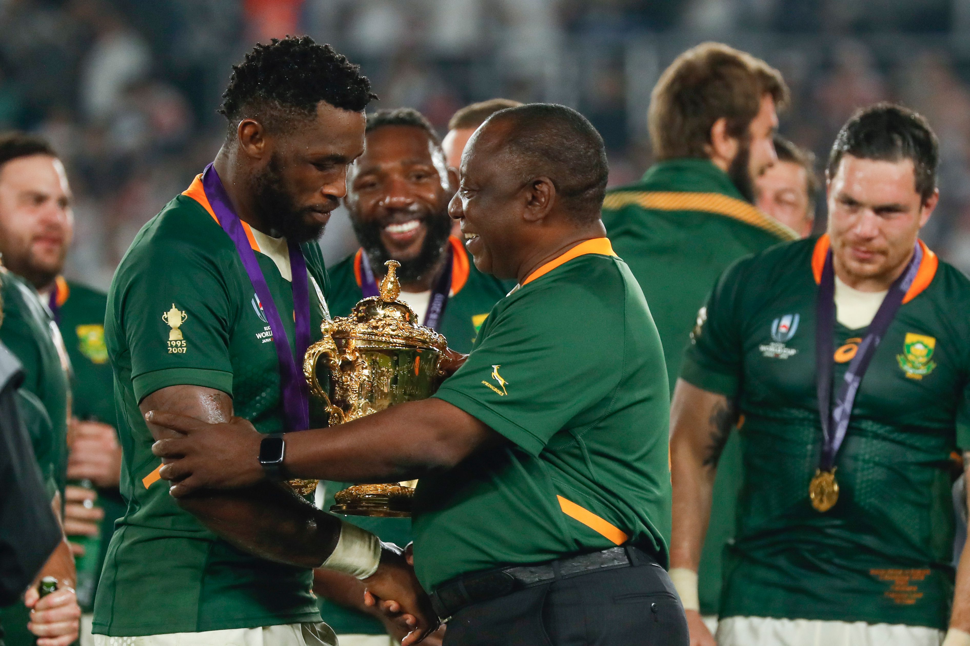 South Africa's President Cyril Ramaphosa (C) congratulates South Africa's flanker Siya Kolisi (L) as they celebrate winning the 2019 Rugby World Cup final.