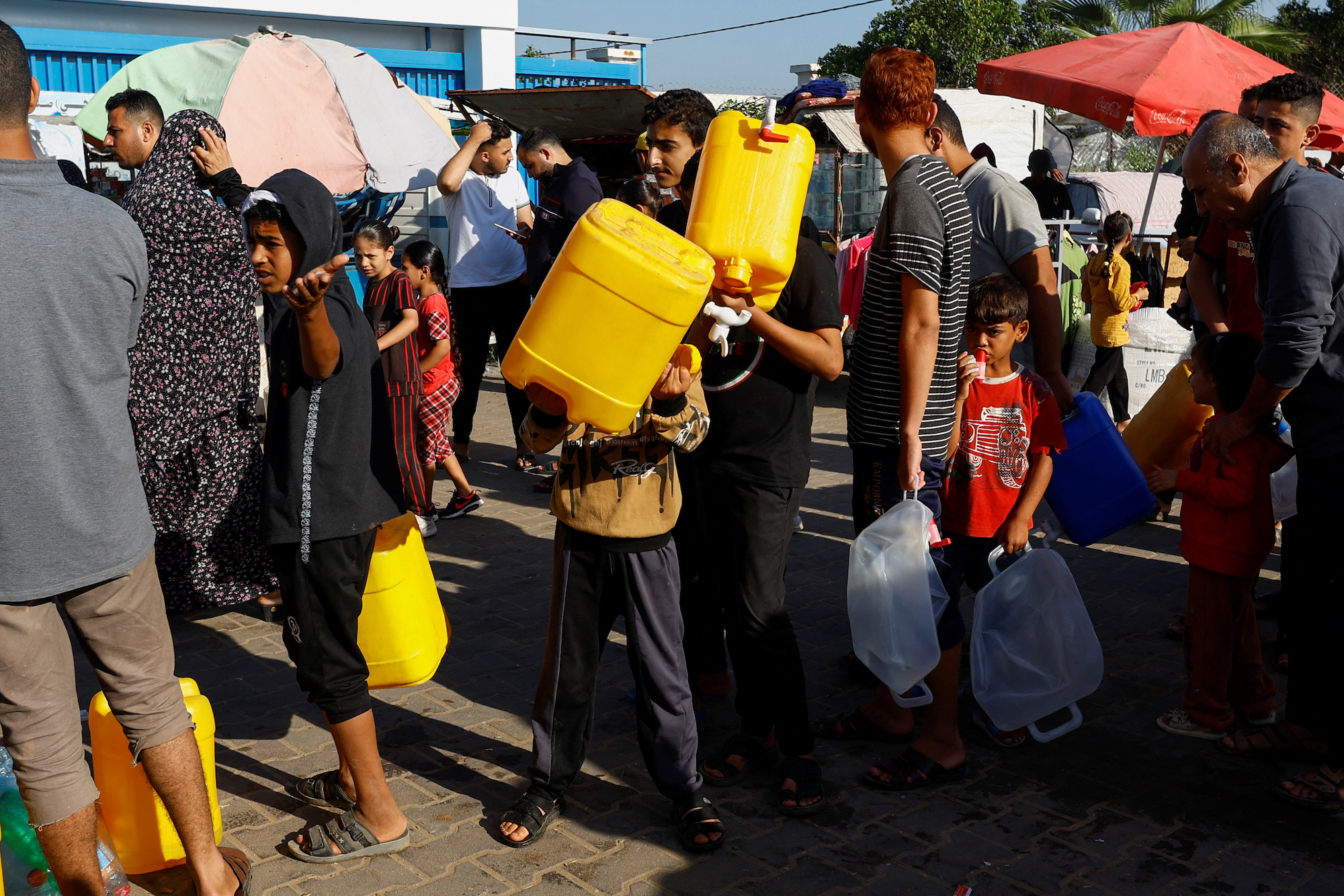 Palestinians queue for water as they take shelter at a United Nations-run centre in Khan Younis on October 26.