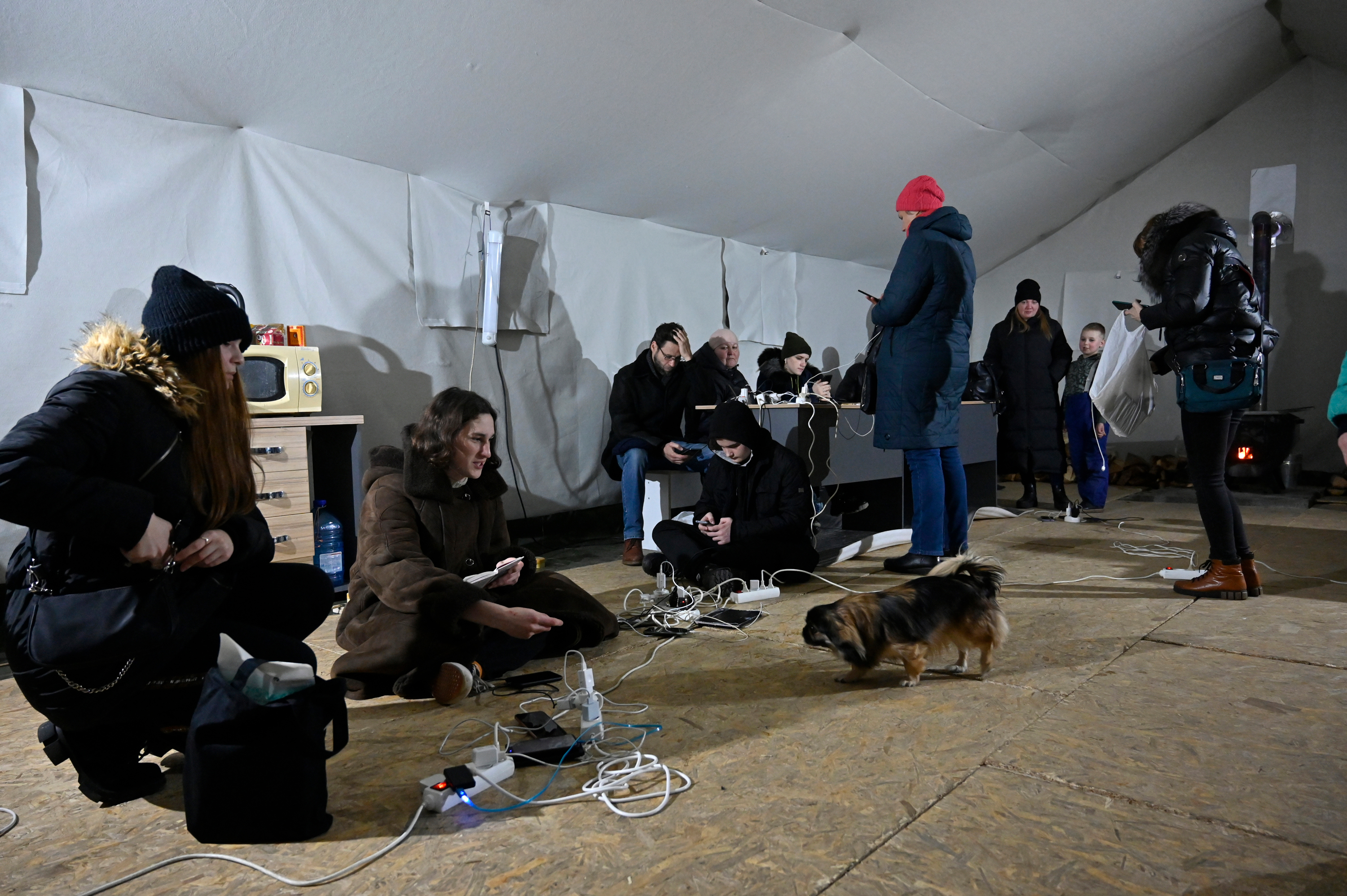 People charge their mobile phones at the mobile police station during a blackout in Kyiv, on December 22.