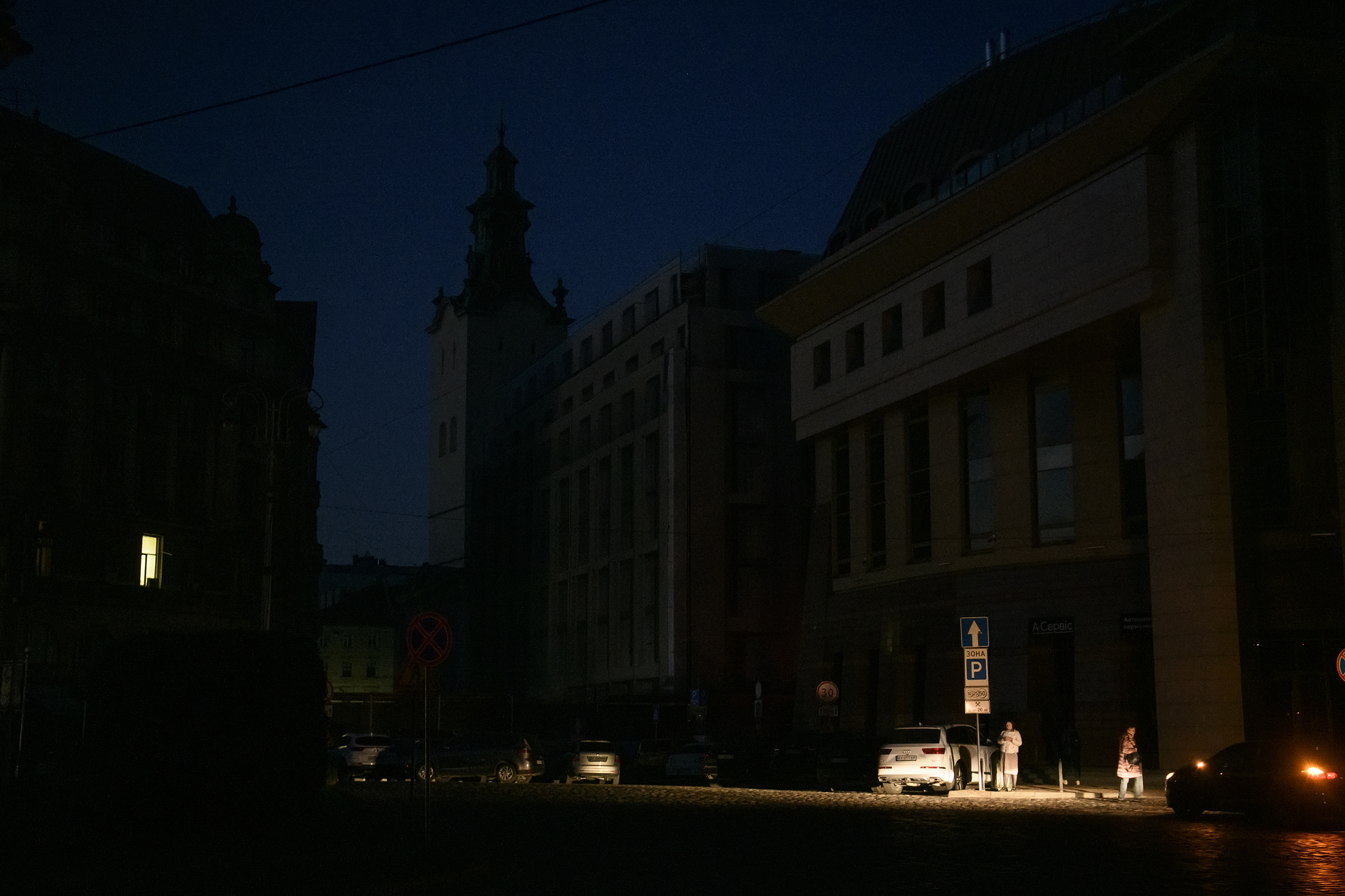 People go by the dark street during a blackout after a massive Russian missile attack on Ukrainian power infrastructure in Lviv, Ukraine, on November 15.
