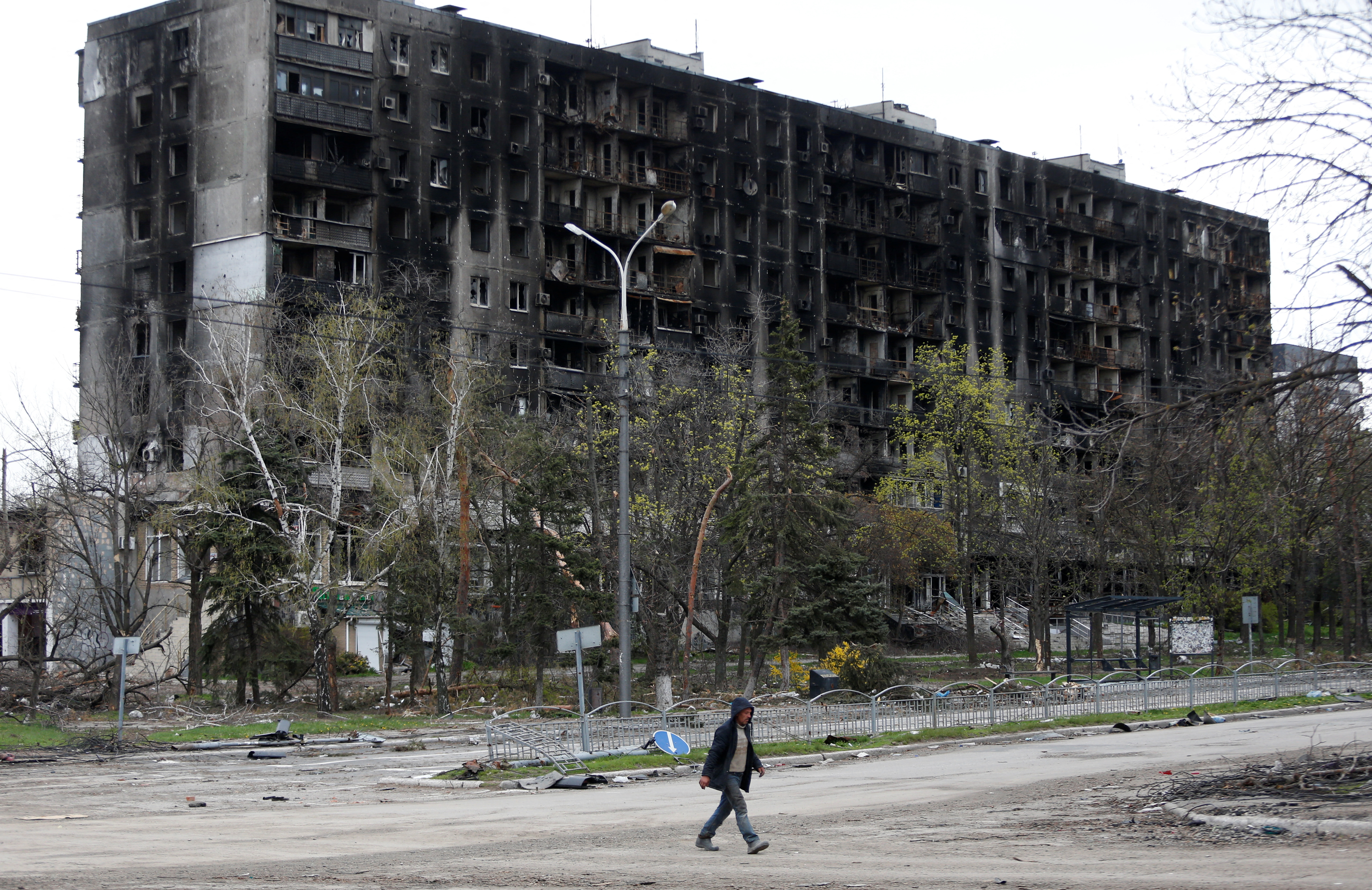 A man walks past a damaged residential building in the southern port city of Mariupol, Ukraine, on April 21.