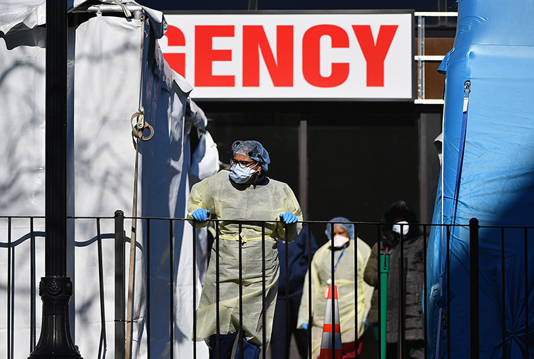 Medical workers outside at Elmhurst Hospital Center in New York City on March 26. Images from the situation at the hospital reportedly played a major role in Trump's decision to keep federal guidelines in place.