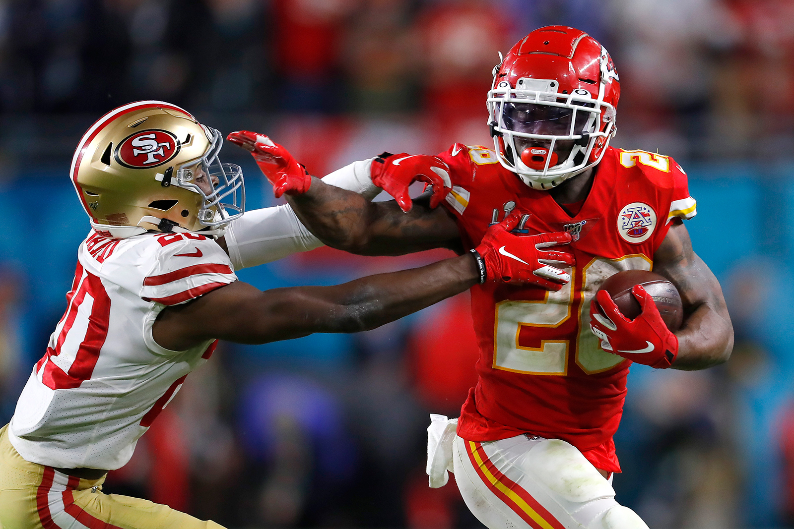 Damien Williams #26 of the Kansas City Chiefs gives a stiff arm to #20 of the San Francisco 49ers during the fourth quarter in Super Bowl LIV at Hard Rock Stadium on February 2, in Miami, Florida.