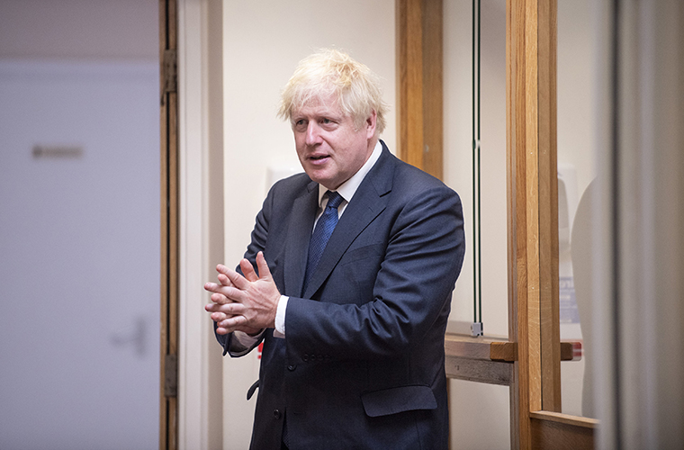 Britain's Prime Minister Boris Johnson sanitizes his hands during a visit to St Joseph's Catholic Primary School in London on Monday Aug. 10, 2020.