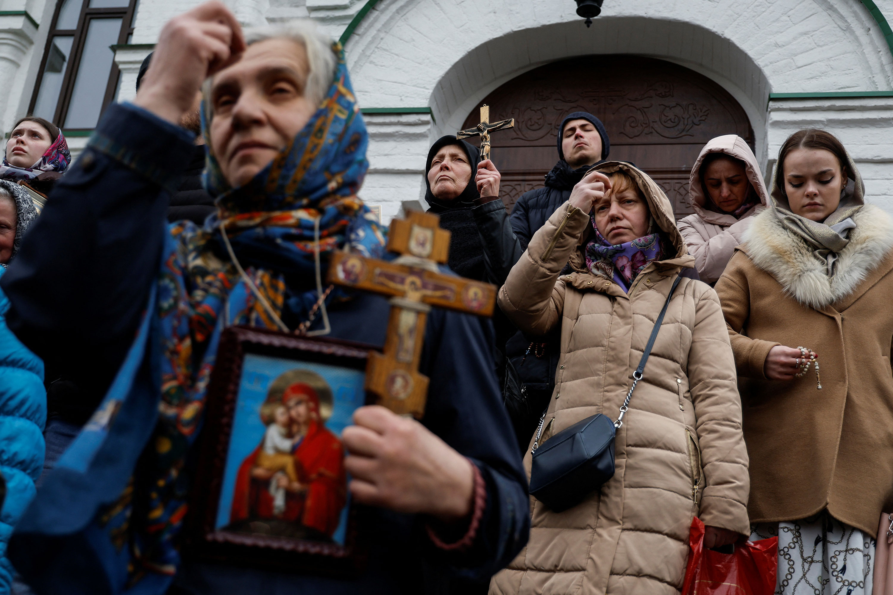 Believers pray blocking an entrance to a church at a compound of the Kyiv-Pechersk Lavra monastery in Kyiv on March 31. 