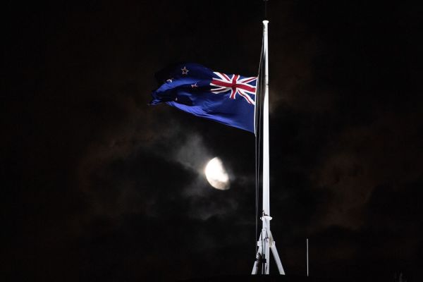 The New Zealand flag flies at half-mast outside the Parliament building in Wellington on Friday evening.