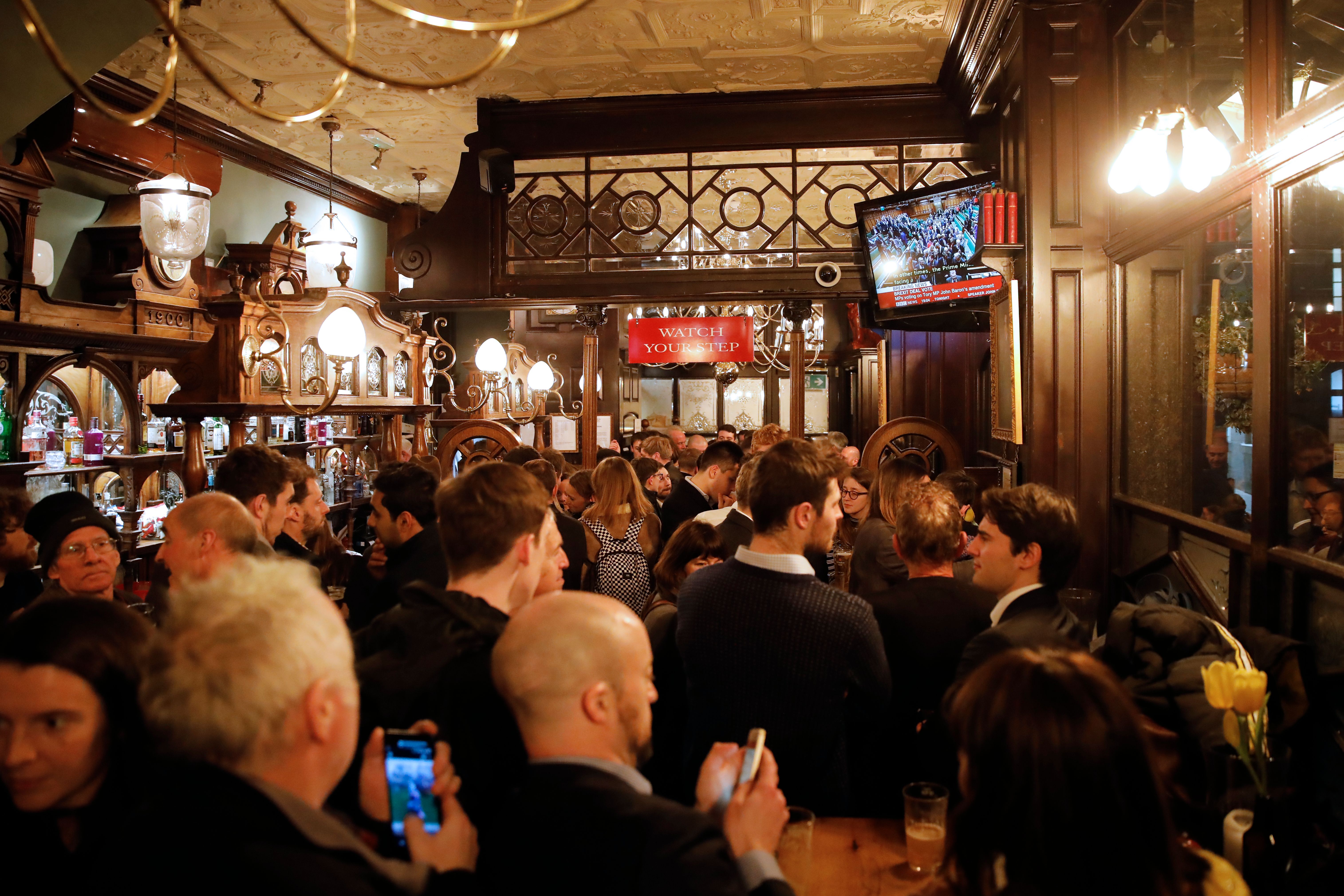 Patrons at a Whitehall pub watch events unfold in Westminster. 