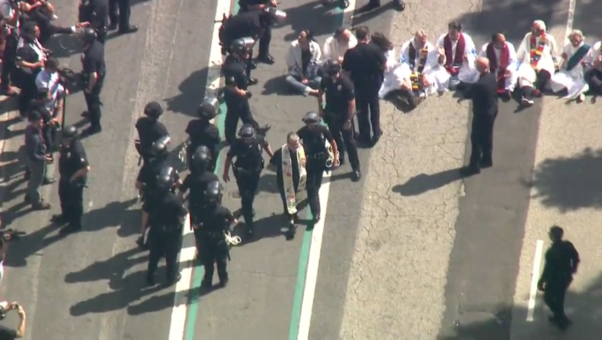 A clergy member is arrested by police while at an immigration protest in downtown Los Angeles.