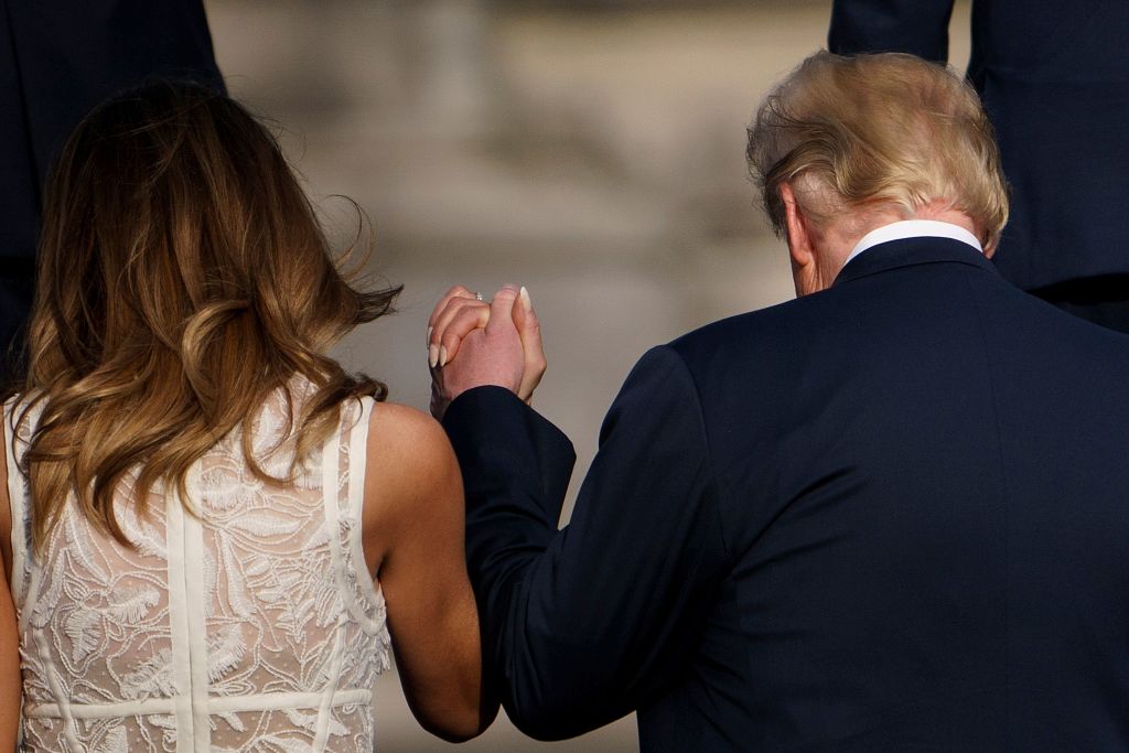 First lady Melania Trump (L) holds hands with President Donald Trump ahead of a working dinner in Brussels on July 11, 2018, during the North Atlantic Treaty Organization (NATO) summit.