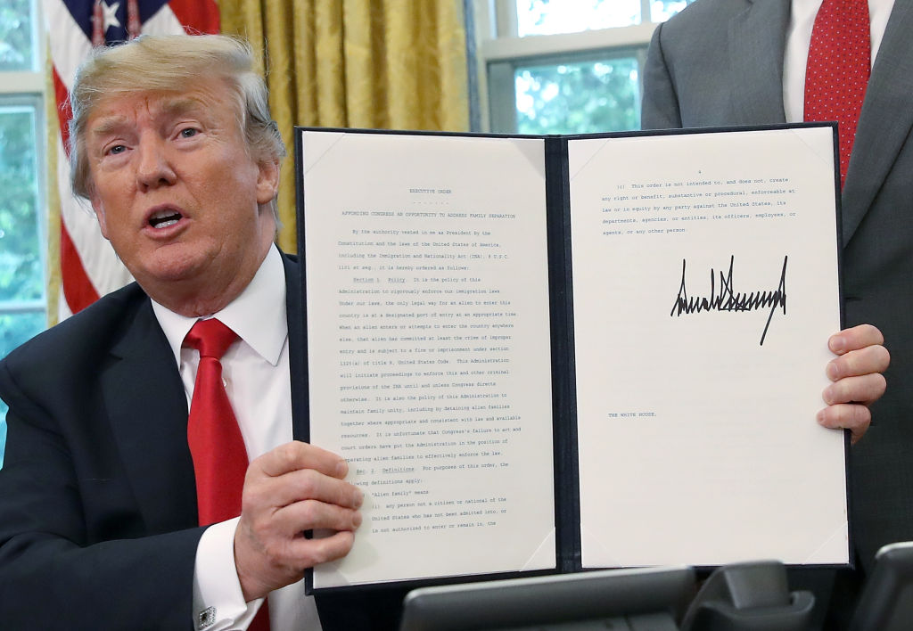 President Donald Trump displays an executive order he signed that will end the practice of separating family members who are apprehended while illegally entering the United States on June 20, 2018 in Washington, DC.