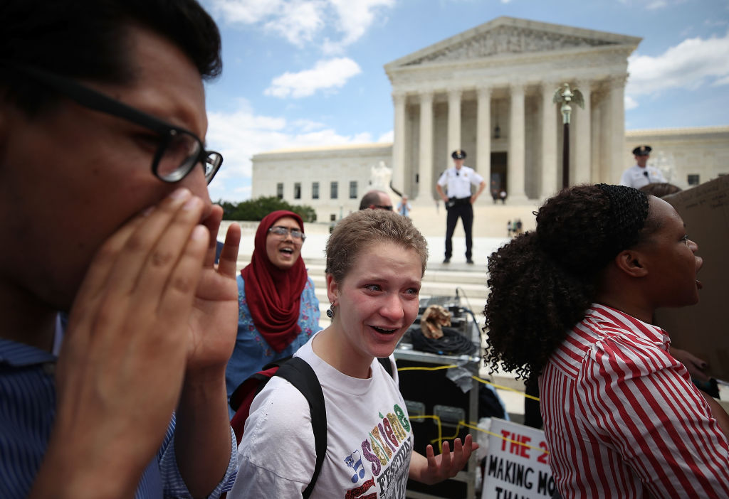 People demonstrate against US President Trump's travel ban as protesters gather outside the U.S. Supreme Court following a court issued immigration ruling June 26, 2018 in Washington, DC.