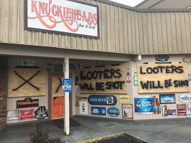 A warning to looters is posted on a bar and grill in Myrtle Beach, South Carolina