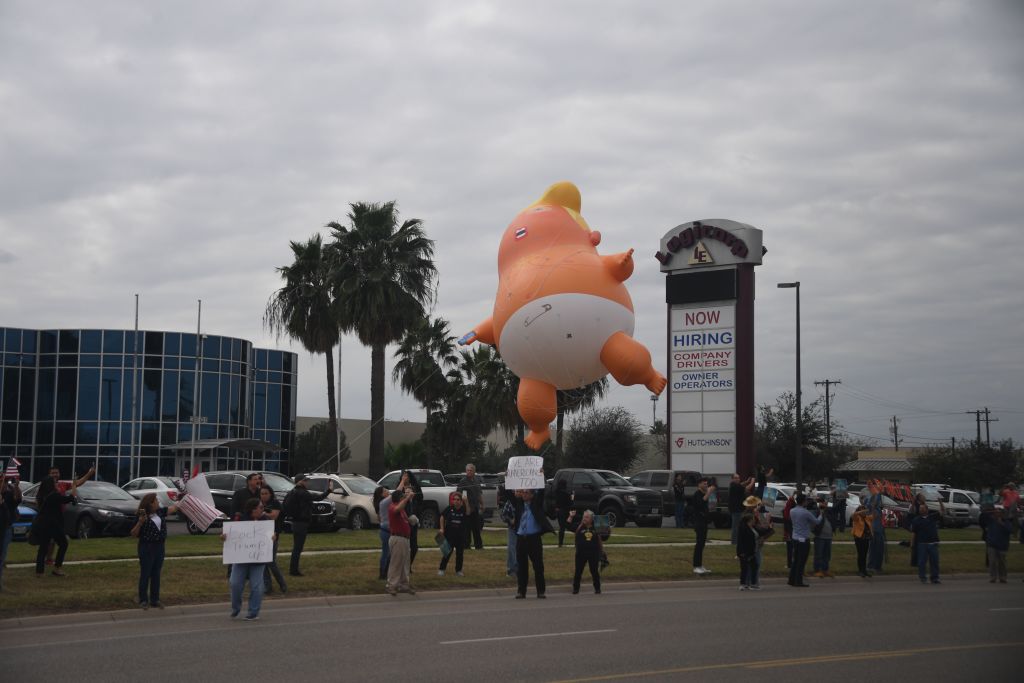 A "Baby Trump" blimp is seen as a motorcade passes supporters and protesters as President Trump travels to US Border Patrol McAllen Station for a roundtable event on Jan. 10, 2019, in McAllen,Texas.