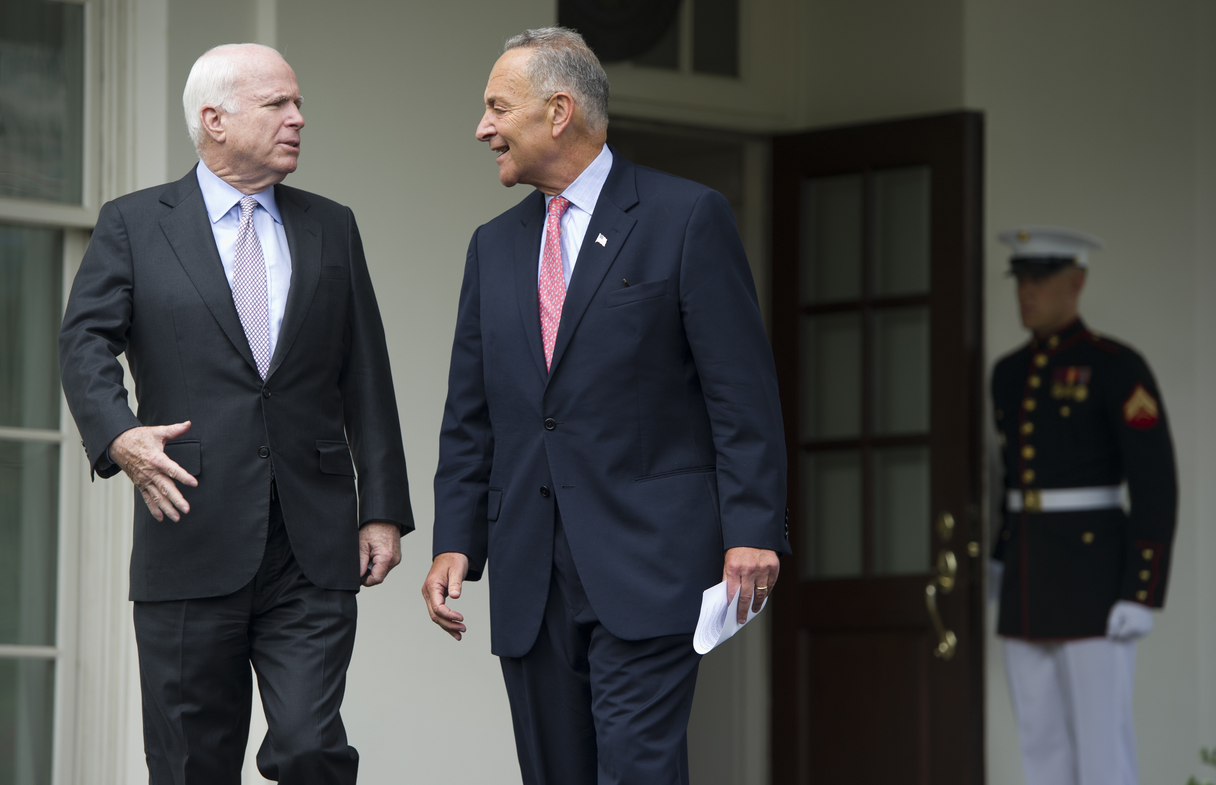 Chuck Schumer (r.) and John McCain walk out of the West Wing of the White House in 2013.