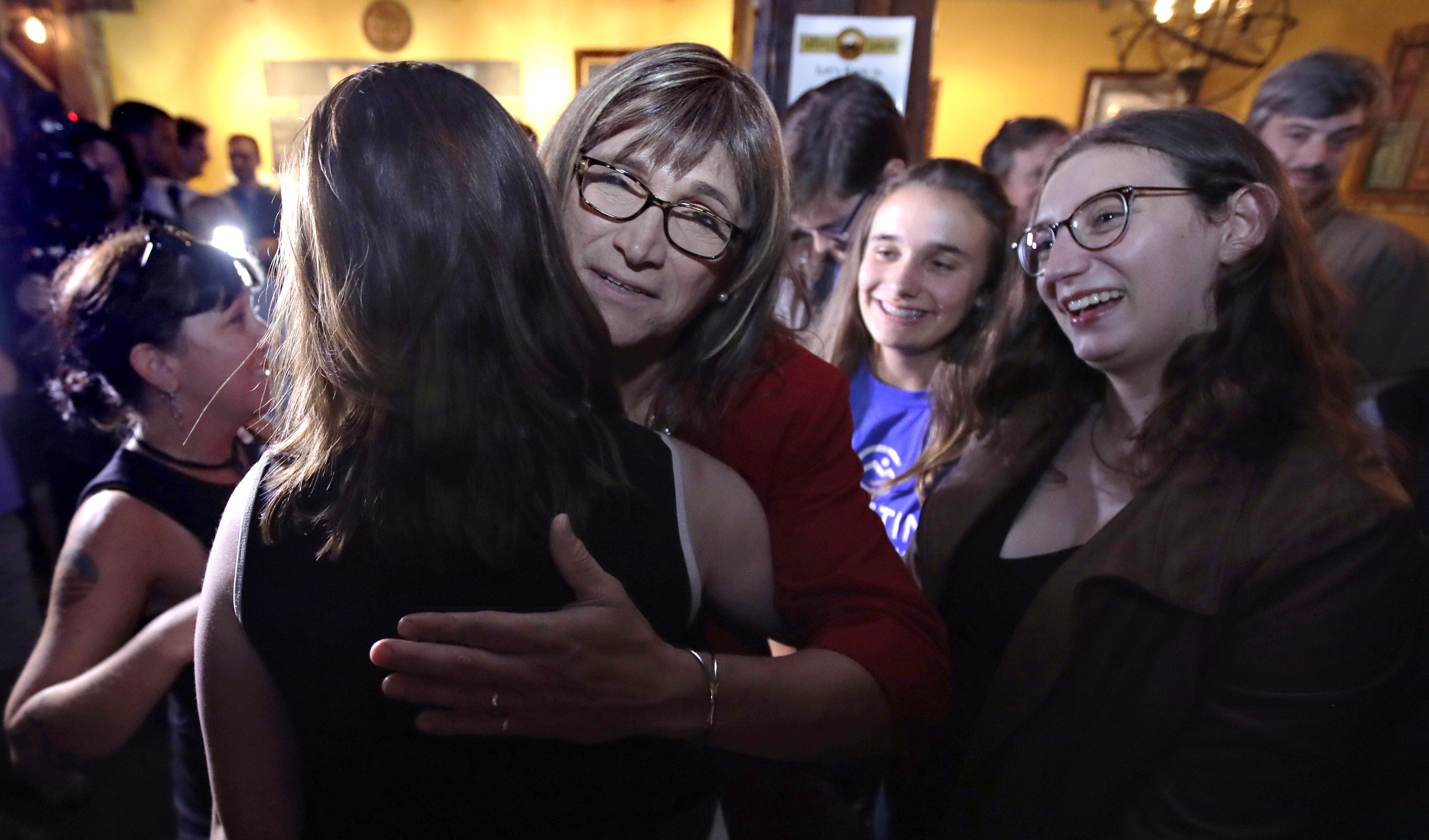 Vermont Democratic gubernatorial candidate Christine Hallquist, center, a transgender woman and former electric company executive, embraces supporters after claiming victory during her election night party in Burlington, Vermont on Tuesday.