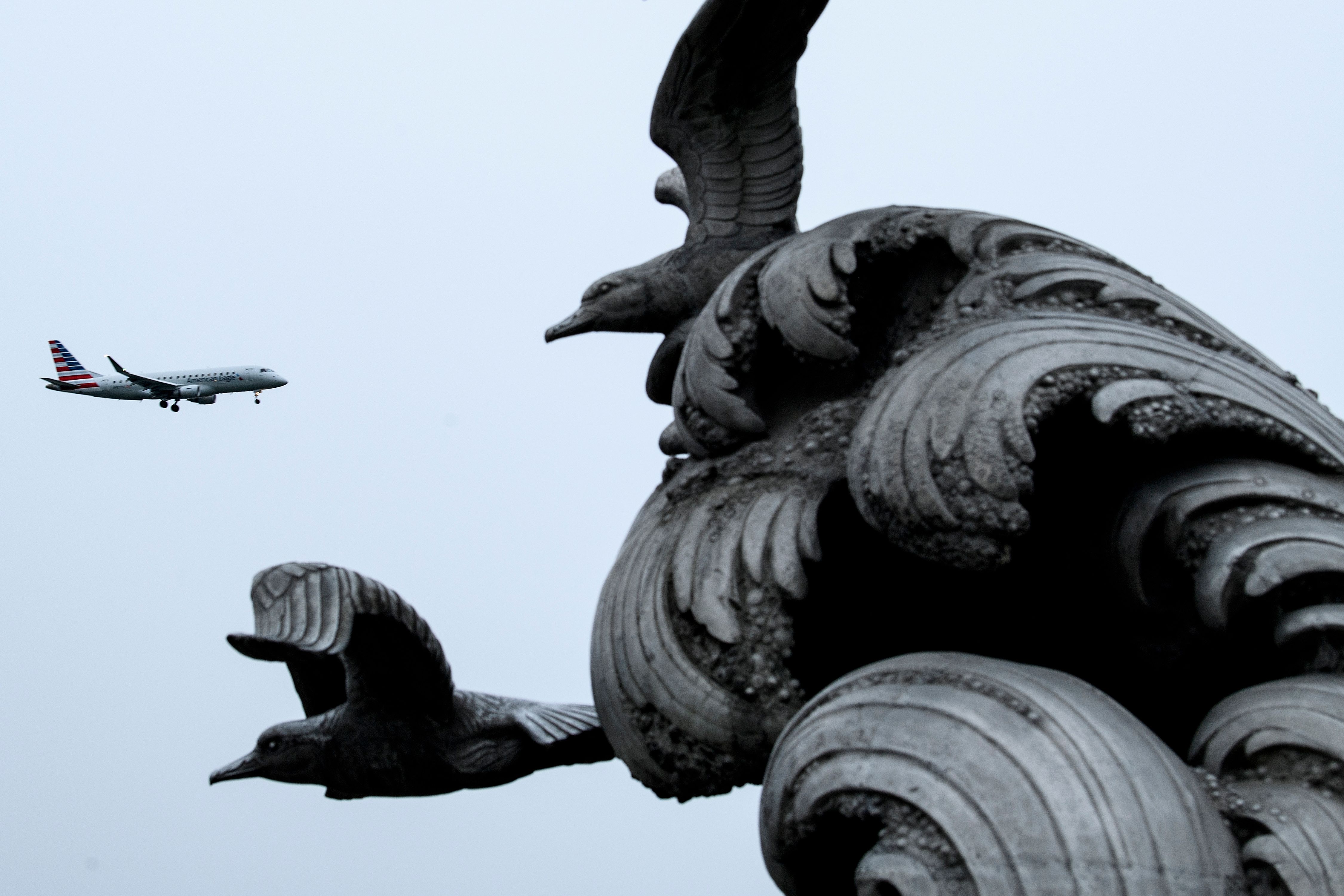 An American Airlines plane passes the Navy - Merchant Marine Memorial 
