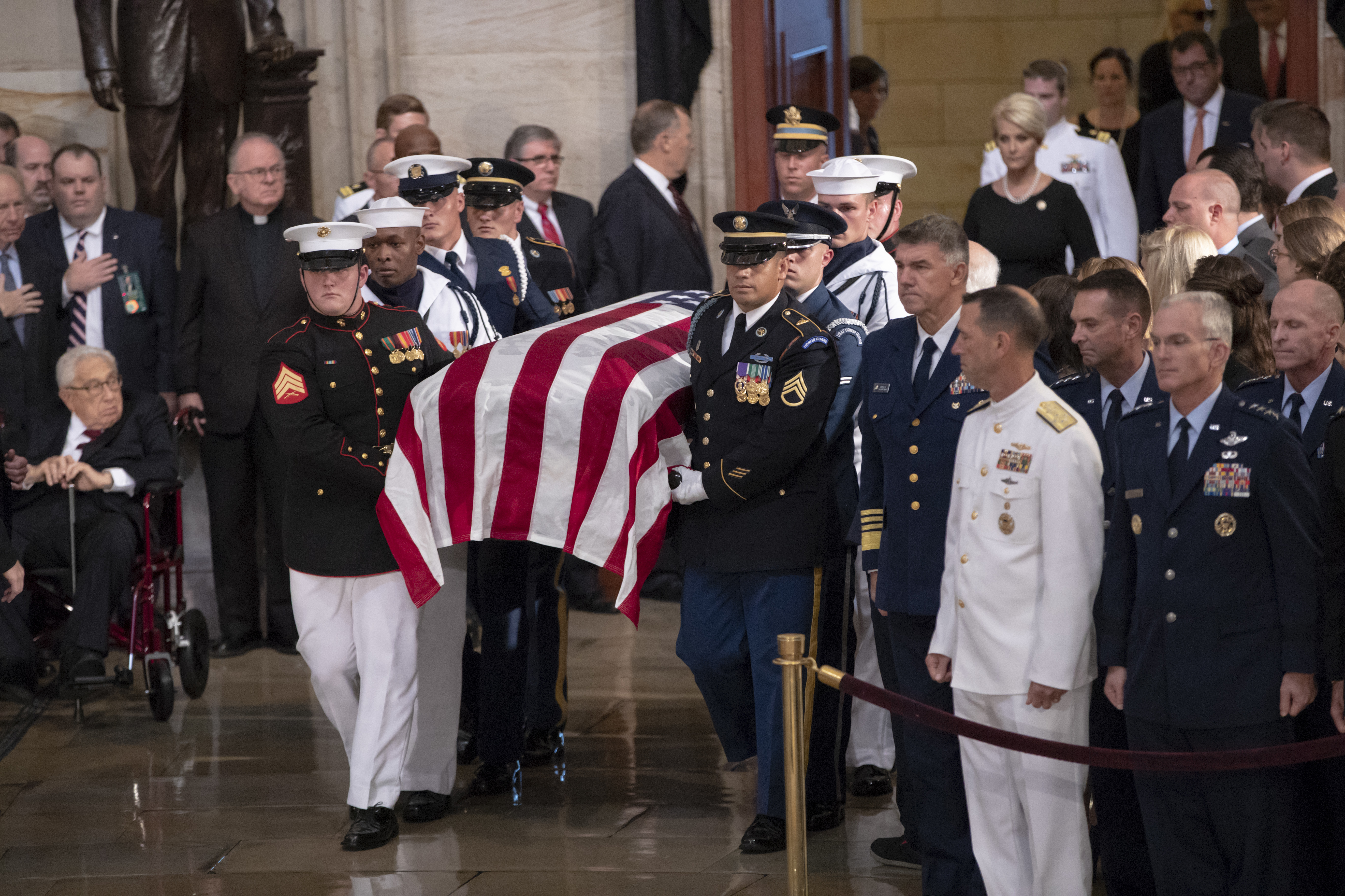 The flag-draped casket bearing the remains of Sen. John McCain of Arizona is carried into the Capitol Rotunda, followed by his widow, Cindy McCain, upper right, for a farewell ceremony and public visitation on Aug. 31, 2018 in Washington. 