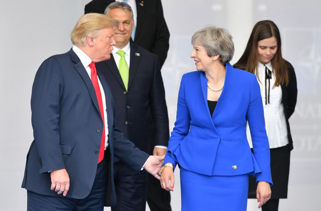 US President Donald Trump (L) gestures as he poses alongside Britain's Prime Minister Theresa May (R) and Iceland's Prime Minister Katrín Jakobsdóttir (R) during the opening ceremony of the NATO summit in Brussels on July 11, 2018.