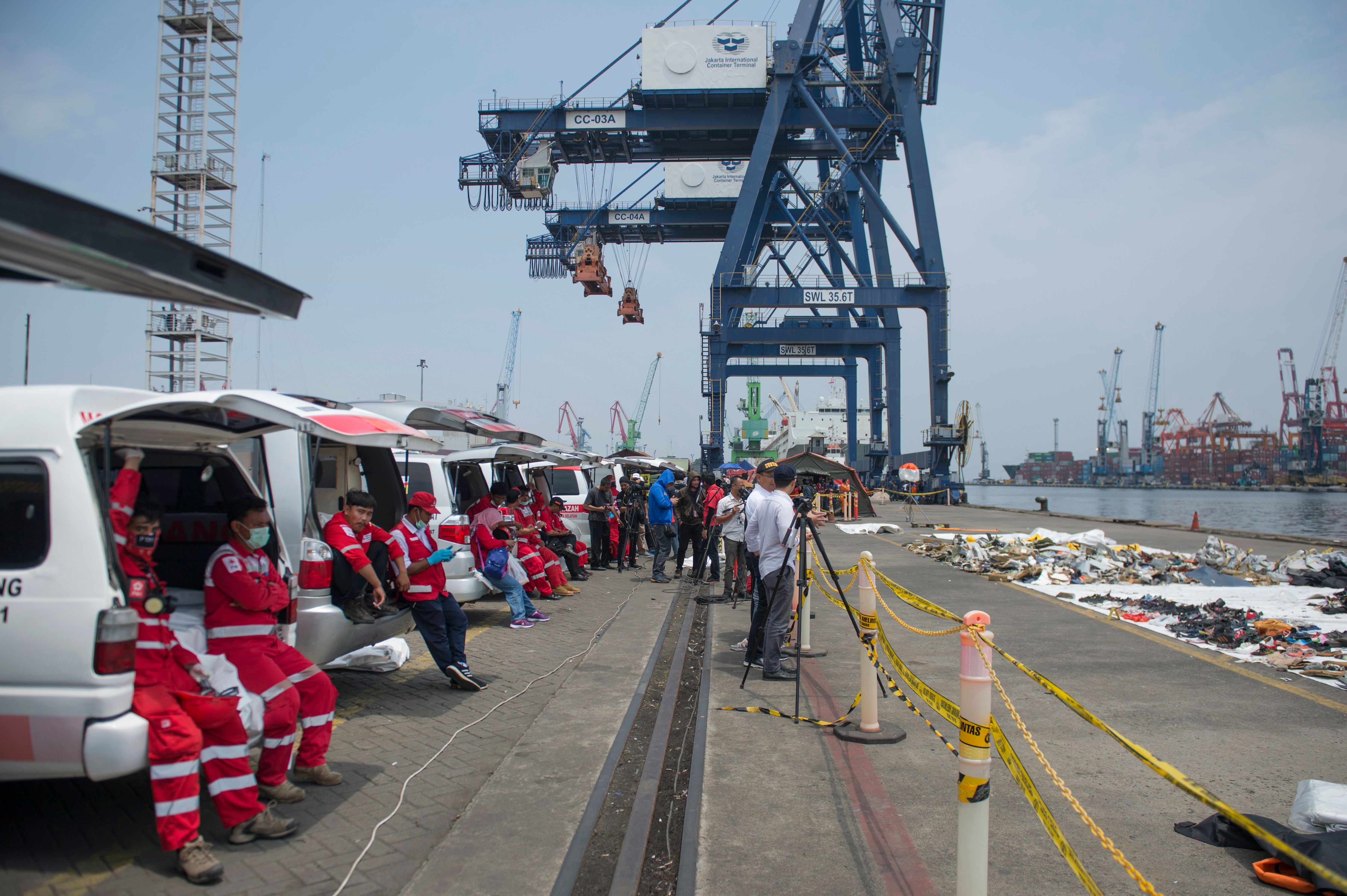 Ambulances sit lined up to transfer recovered victims of the ill-fated Lion Air flight JT 610 as debris collected at sea sits out to dry, at the Jakarta International Container Terminal in Jakarta. 