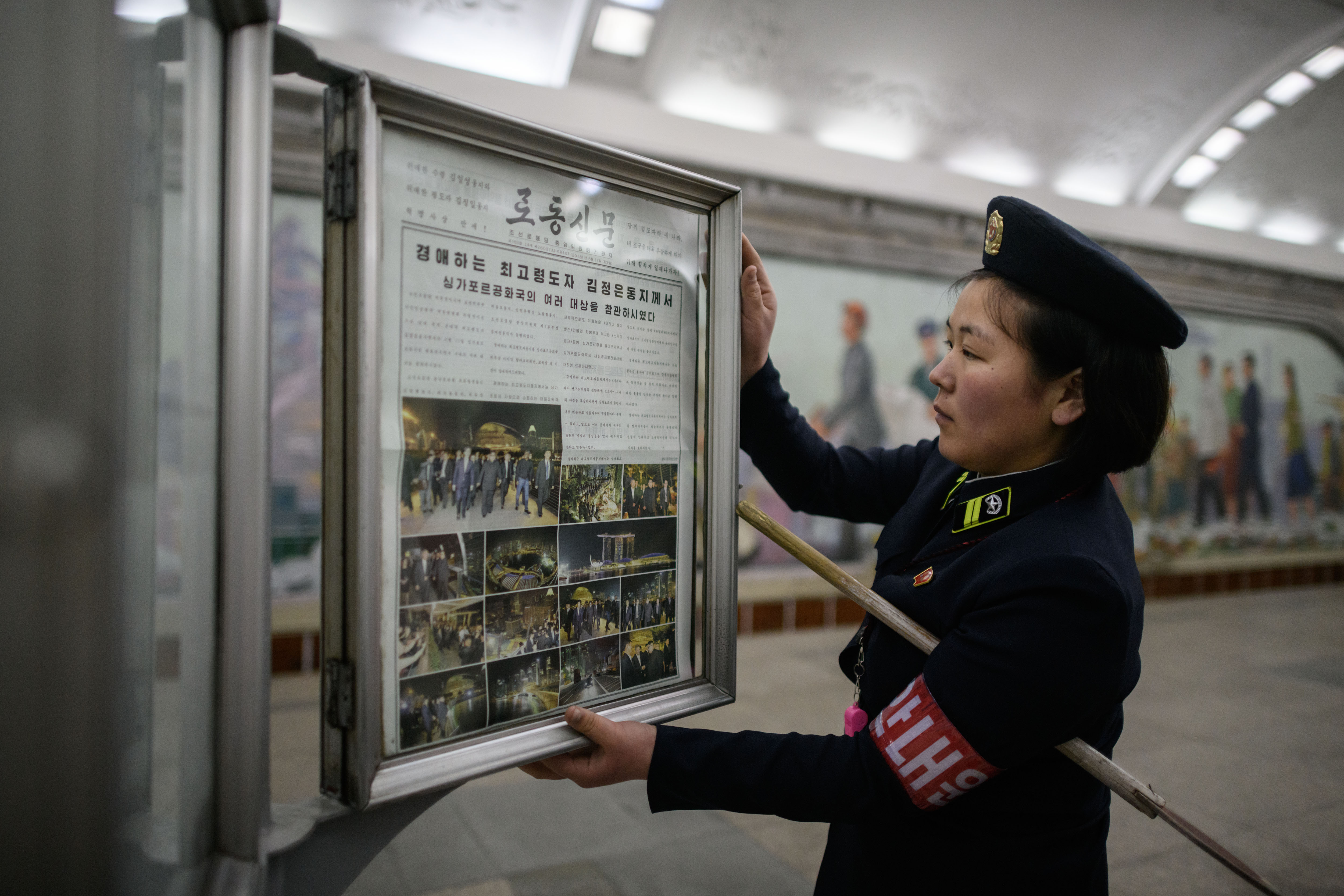 A conductor changes the Rodong Sinmun newspaper showing images of North Korean leader Kim Jong Un in Singapore ahead of his meeting with Trump.