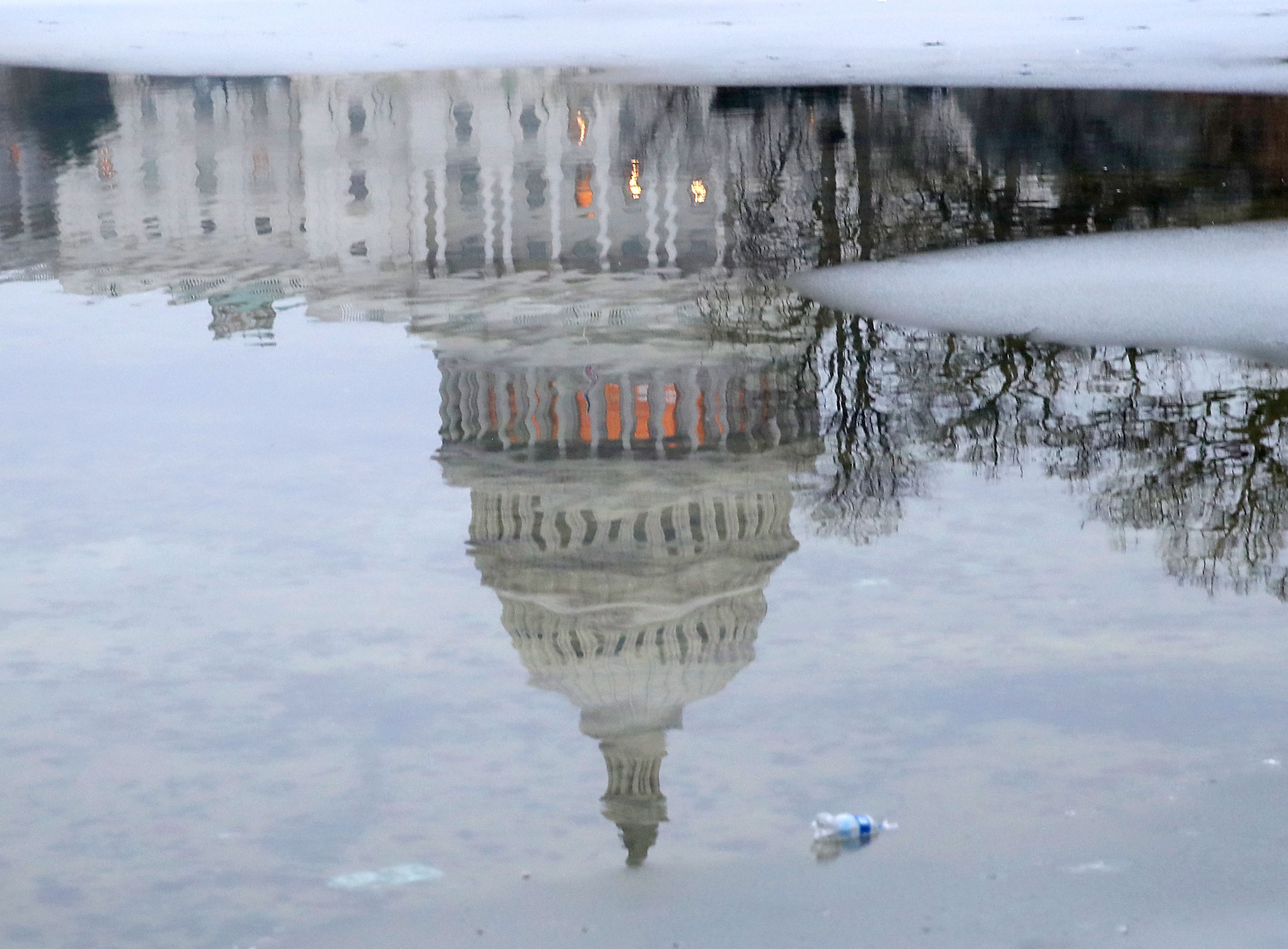 The US Capitol is reflected onto a partially frozen reflecting pool on Friday.