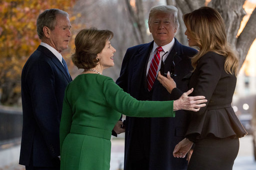 President Donald Trump and first lady Melania Trump are greeted by former President George Bush and former first lady Laura Bush outside the Blair House across the street from the White House in Washington, Tuesday, Dec. 4, 2018