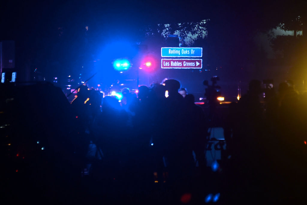 People gather as close as they can to the Borderline Bar & Grill in Thousand Oaks, California, on Nov. 8, 2018 as police vehicles closed off the area responding to a shooting.