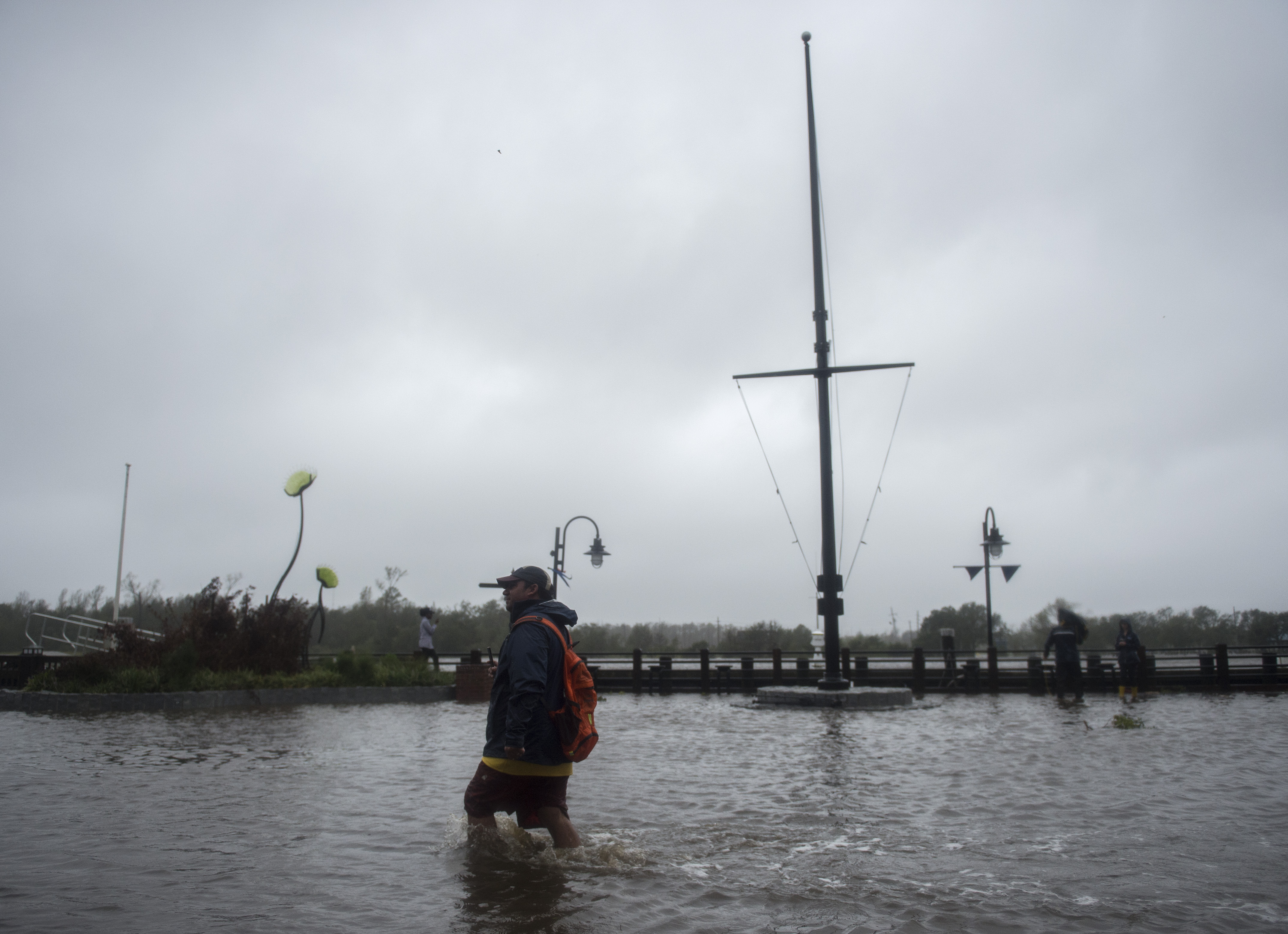 A man wades through rising flood waters on the Cape Fear River in Wilmington, North Carolina, on Friday.