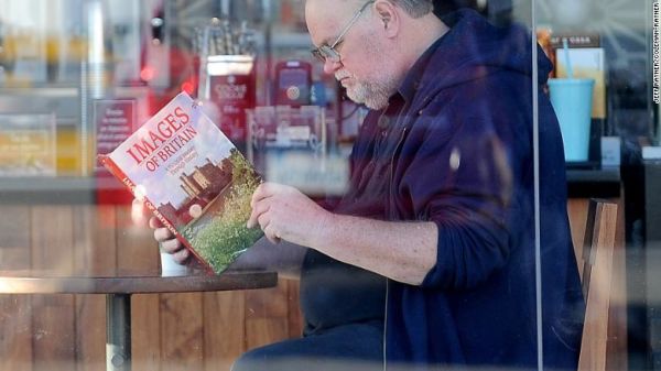 Thomas Markle reading a book titled "Images of Britain," in an allegedly staged photo.