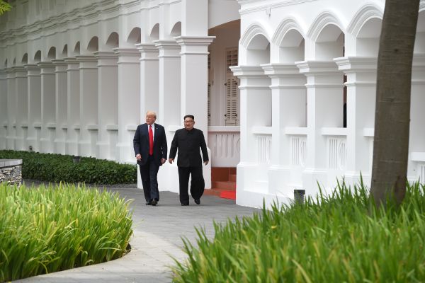 North Korea's leader Kim Jong Un (R) walks with US President Donald Trump (L) during a break in talks on June 12.