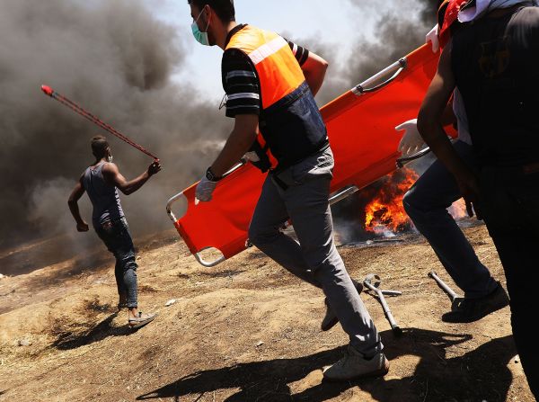 Medics rush in as Palestinians clash with Israeli soldiers at the border fence with Israel as mass demonstrations at the fence continue on May 14, 2018 in Gaza City, Gaza.