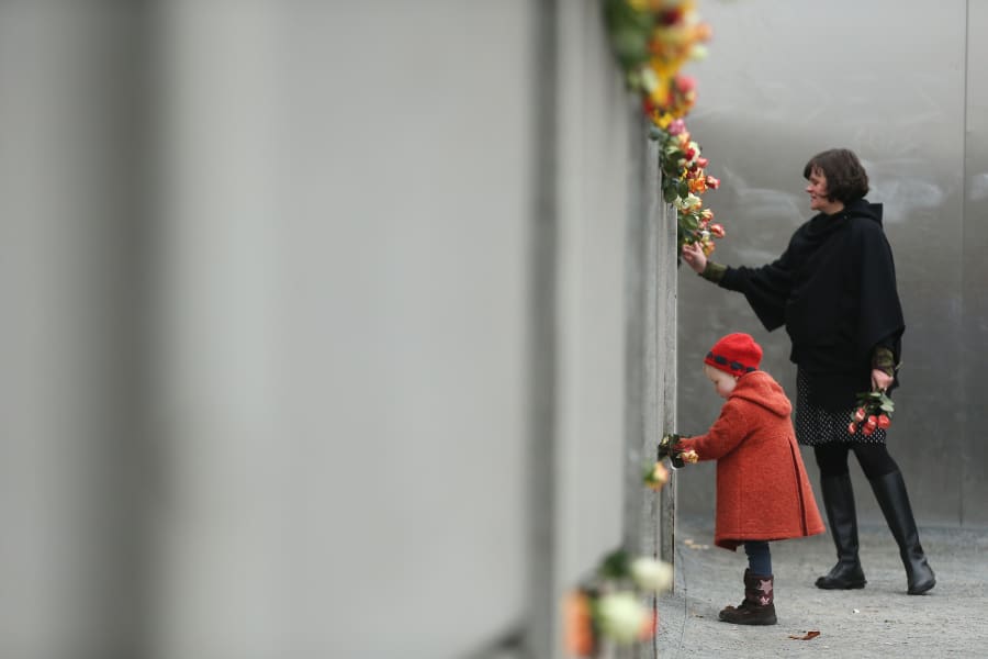 Berlin Wall commemoration girl flowers