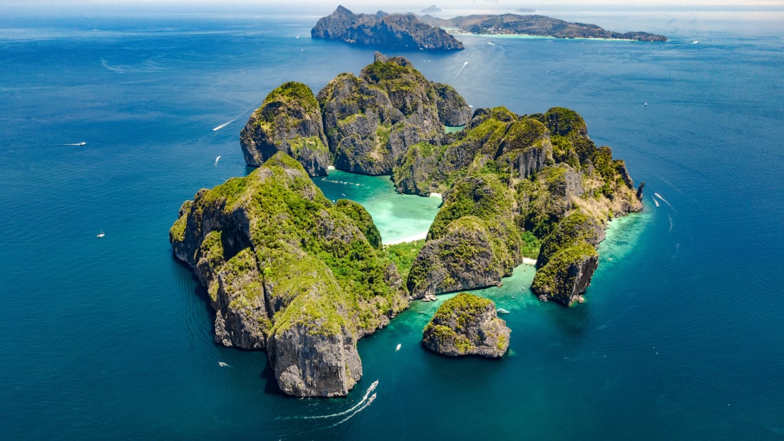 从空中俯瞰热带皮皮岛、海滩和蓝色清澈安达曼海水中的船只、泰国甲米美丽的群岛