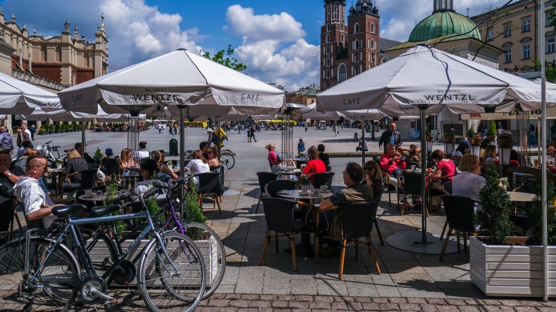 KRAKOW, POLAND - MAY 15: People enjoy drinks and food on an outdoor garden bar at Krakow's UNESCO listed Main Square on May 15, 2021 in Krakow, Poland. Bars and restaurants reopen after 7 months of closure as the infection rates continue to decline.From today, the obligation for people to cover their nose and mouth in outdoor public spaces is lifted, bars and restaurants will be allowed to serve drinks and food outside, with obligatory mask wearing for workers and guests while taking their seats among others. (Photo by Omar Marques/Getty Images)