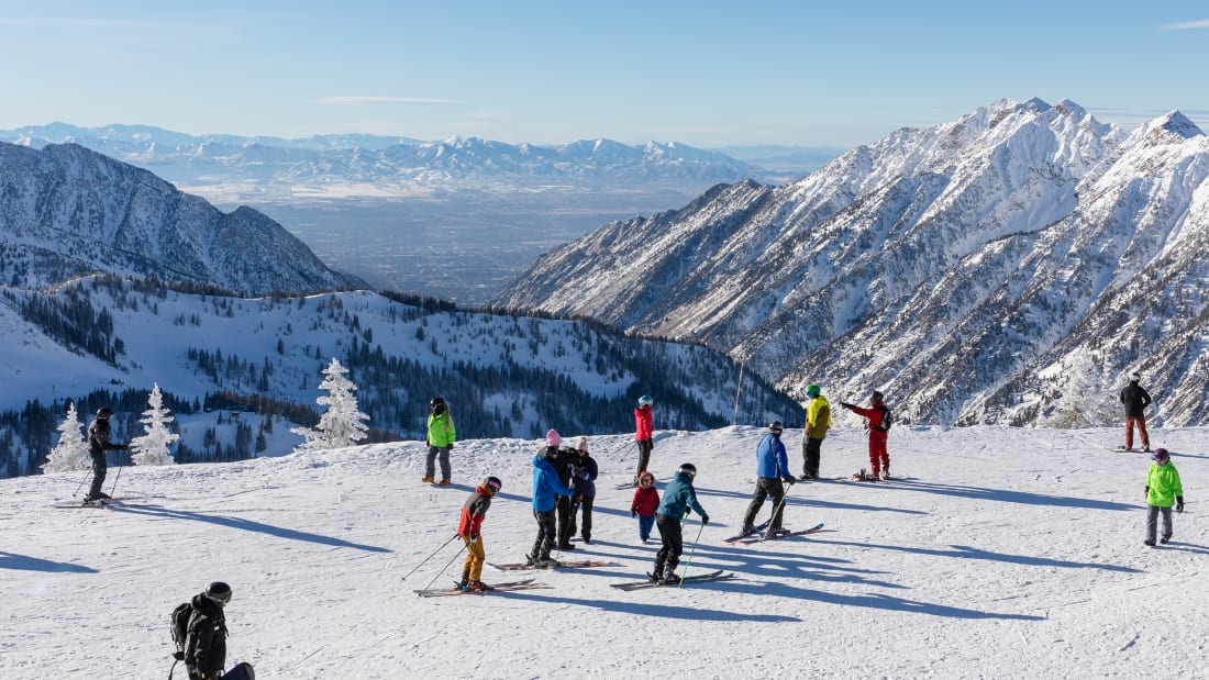 Skiers and snowboarders on top of Hidden Peak ready to ski down at Snowbird Ski Resort in Little Cottonwood Canyon in the Wasatch Range near Salt Lake City, Utah, USA. 