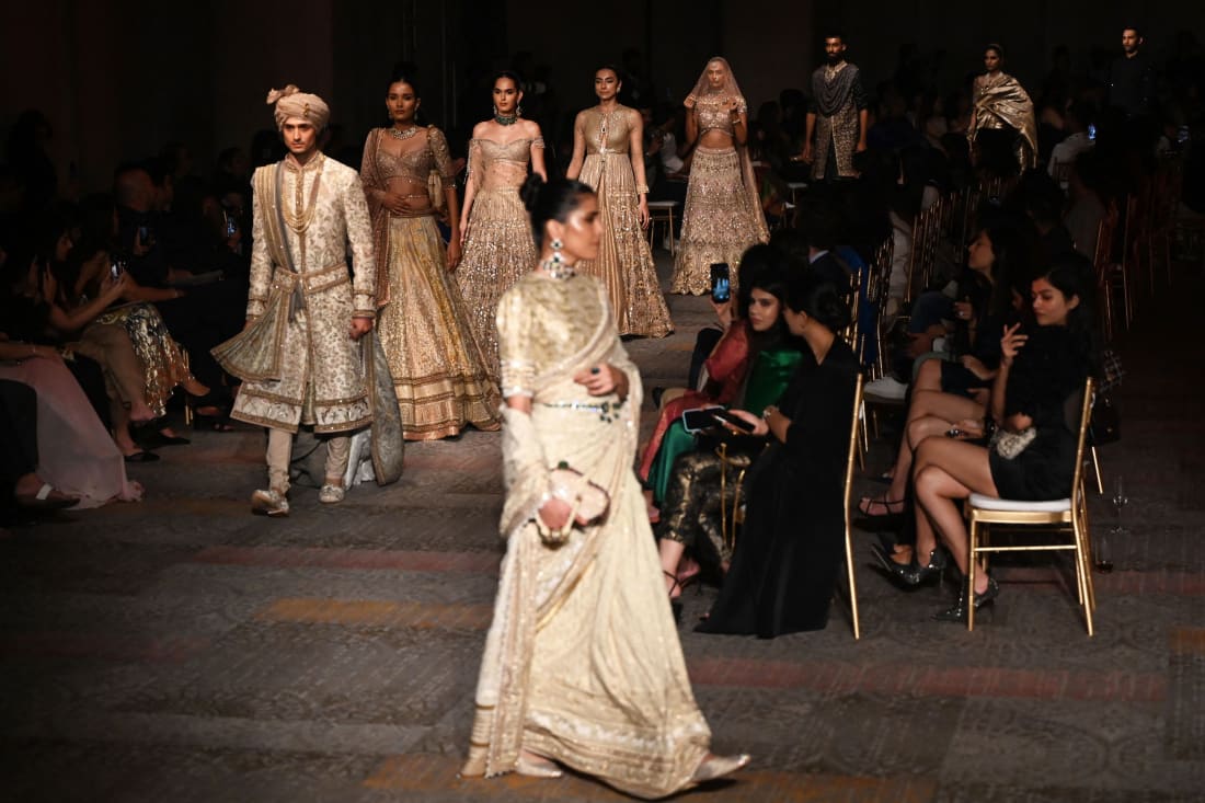 Models present creations by designer Tarun Tahiliani during the FDCI India Couture Week in New Delhi on July 22, 2022. 