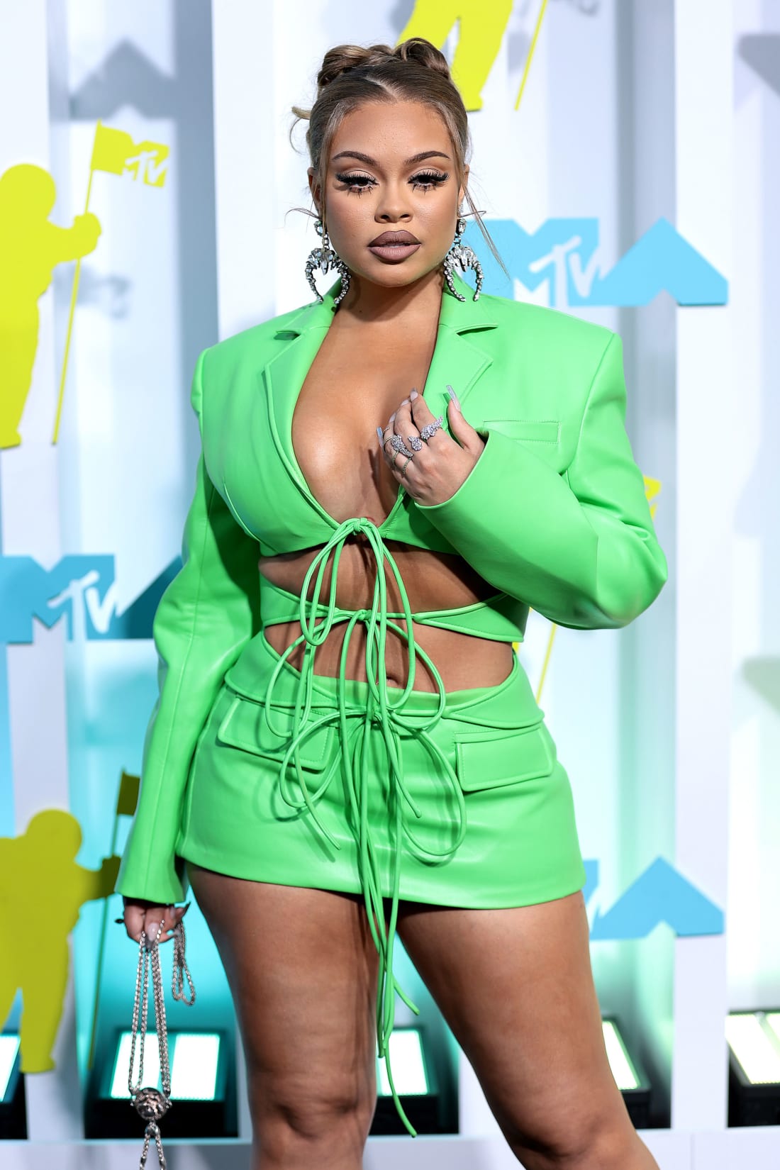 Bright greens popular on the VMAs carpet, with rapper Latto wearing a lace-up mini dress in a neon shade.
