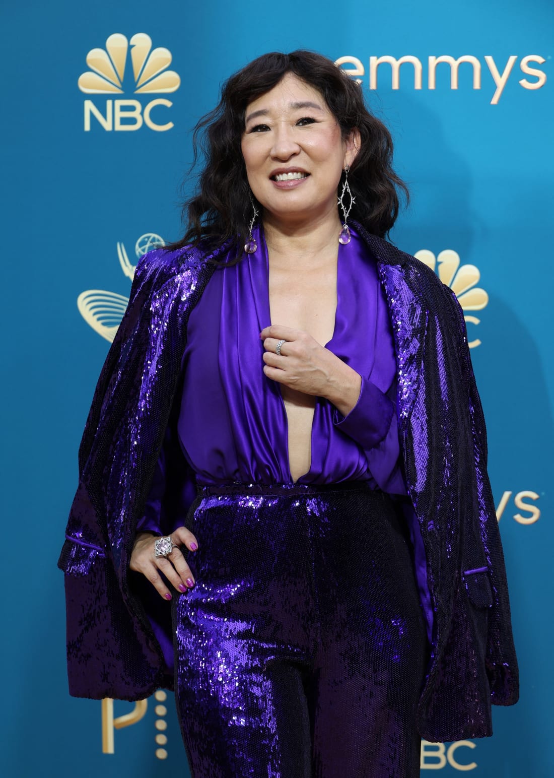 Sandra Oh arrived on the carpet wearing a sequined purple jumpsuit and cape by Rodarte.