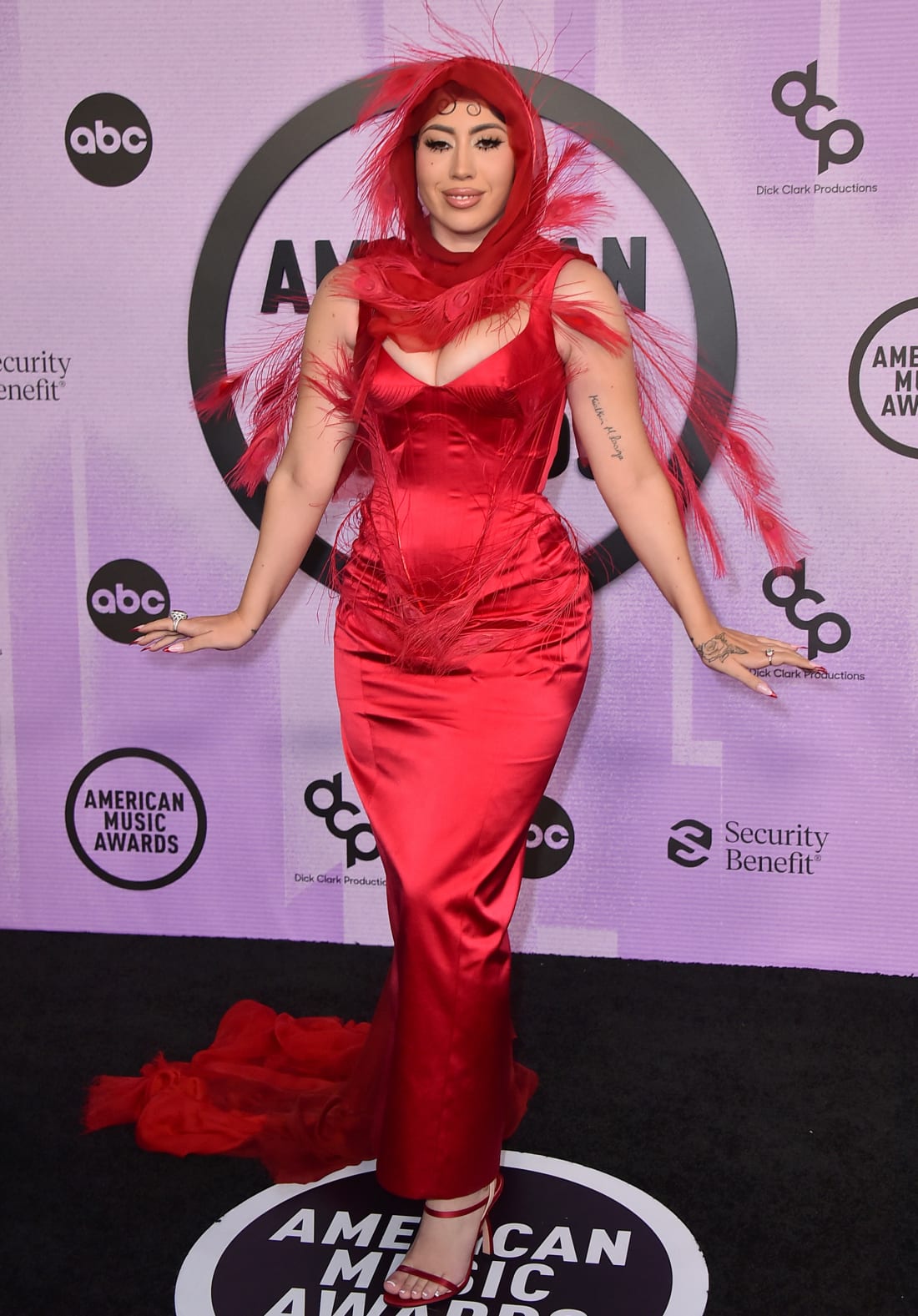 Kali Uchis wore an ankle-length red gown with a feathered hood.  