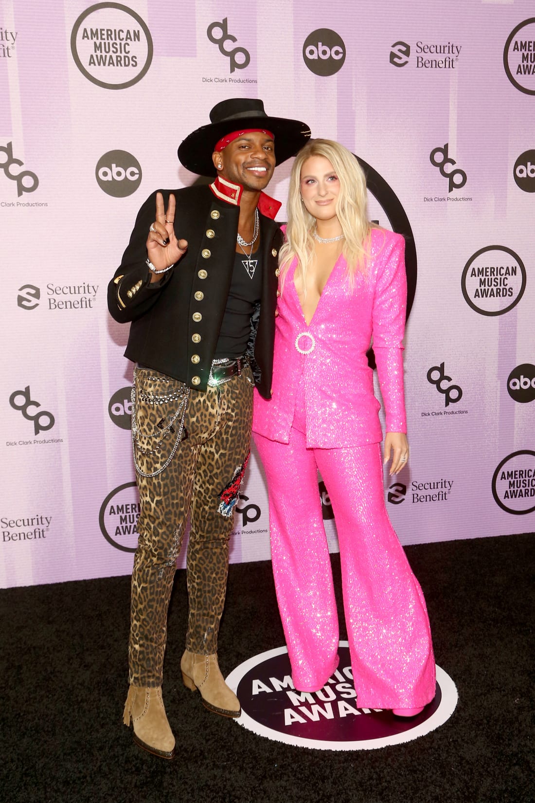Awards presenters Jimmie Allen and Meghan Trainor pose together on the red carpet. 