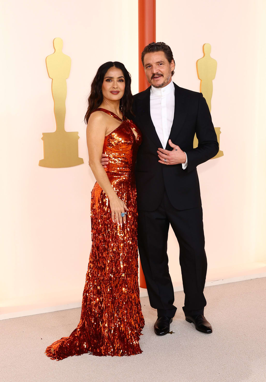 Salma Hayek and Pedro Pascal wearing Gucci and Zegna, respectively.
