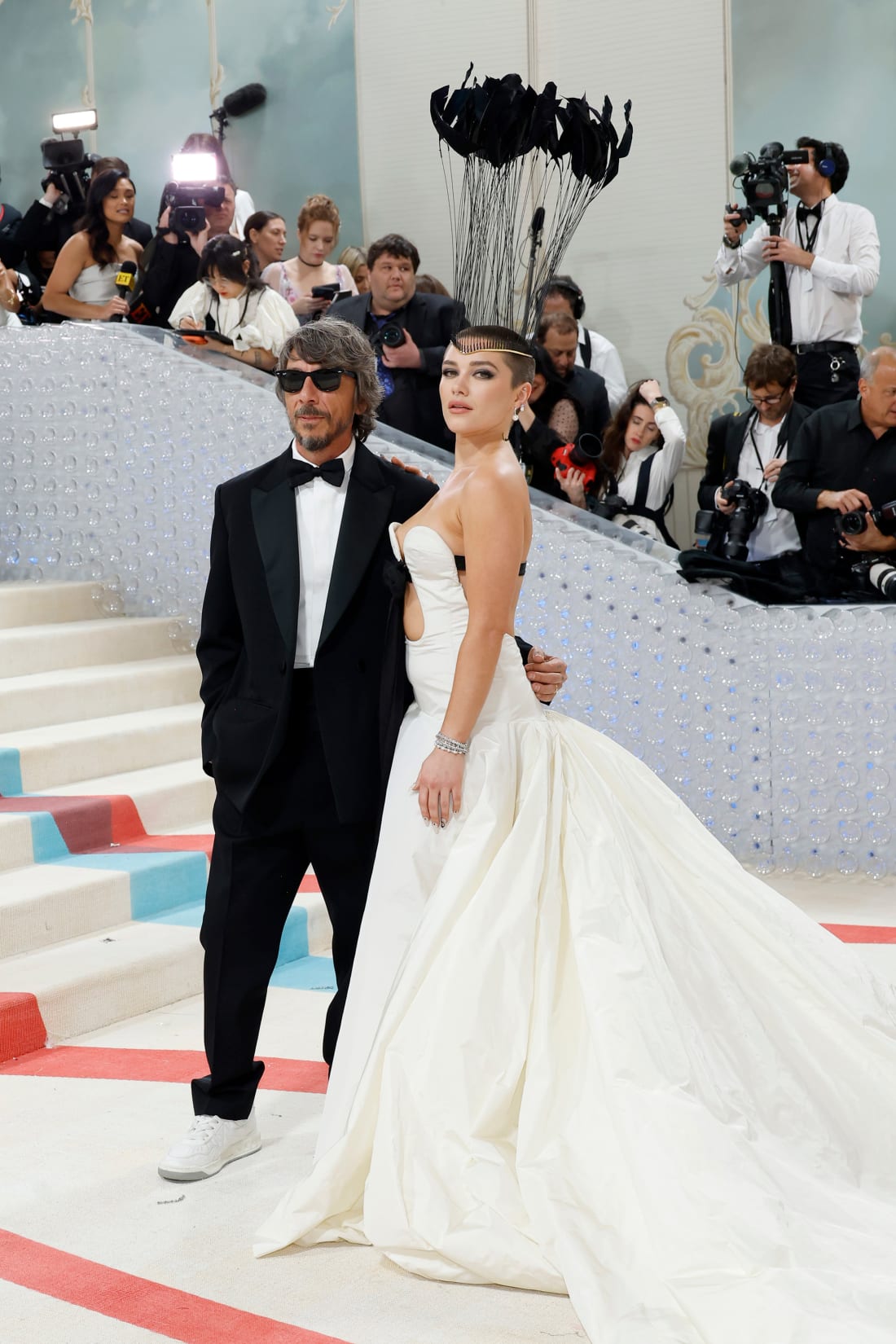 Valentino creative director Pier Paolo Piccioli with Florence Pugh (who debuted a shaved head) wearing a towering black headpiece and trailing white Valentino gown.
